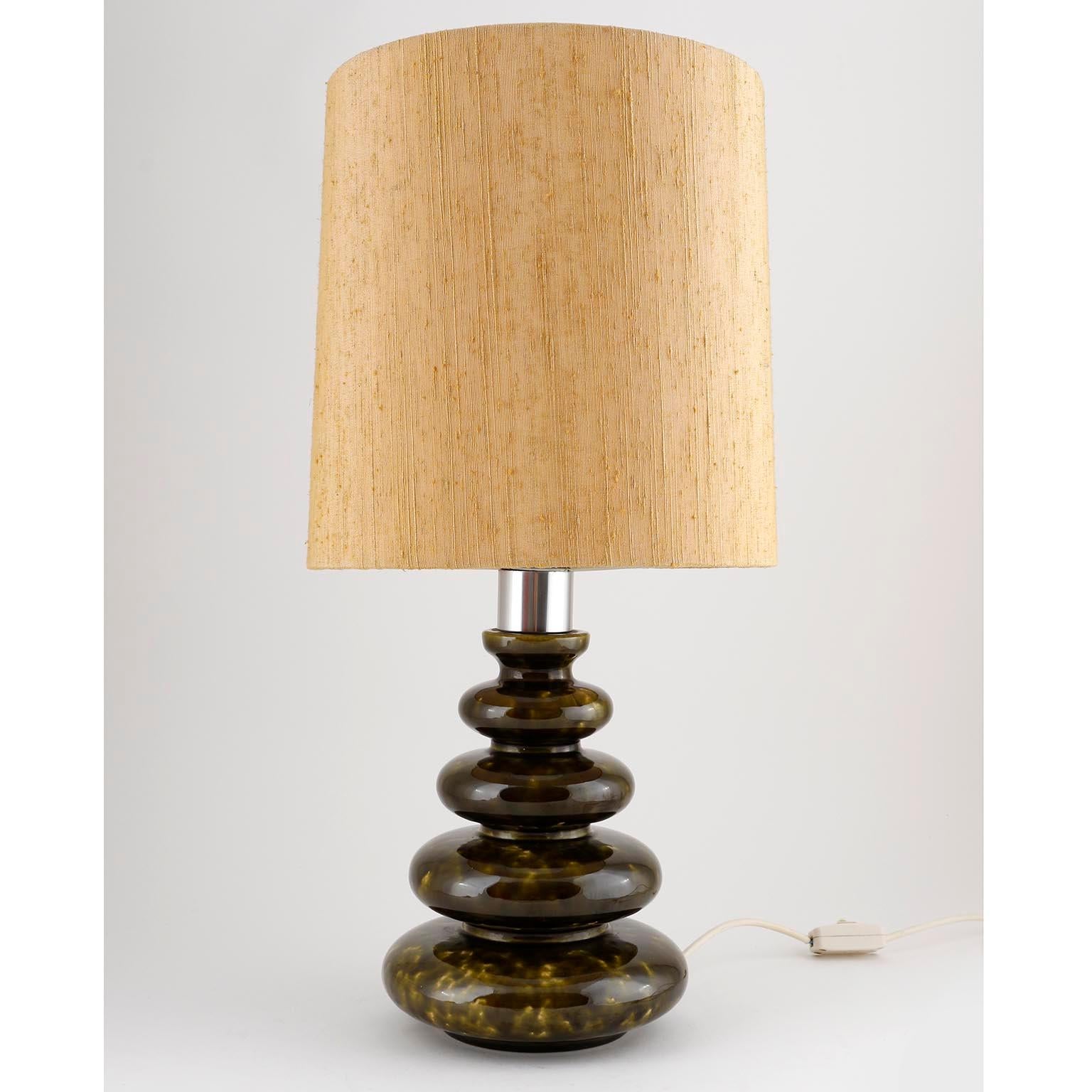 A pair of table lamps manufactured in midcentury, circa 1970s.
The stand is made of a light and dark or moss green-brindled glazed ceramic Stand with and a chromed lamp shade holder.
The original lampshades are in good condition and made of a