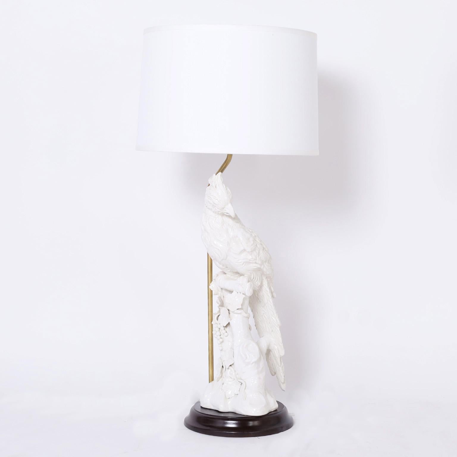 Chic pair of mid century Italian large scale table lamps crafted in earthenware with a white glaze in the form of a parrot perched on a tree and presented on an ebonized wood base.