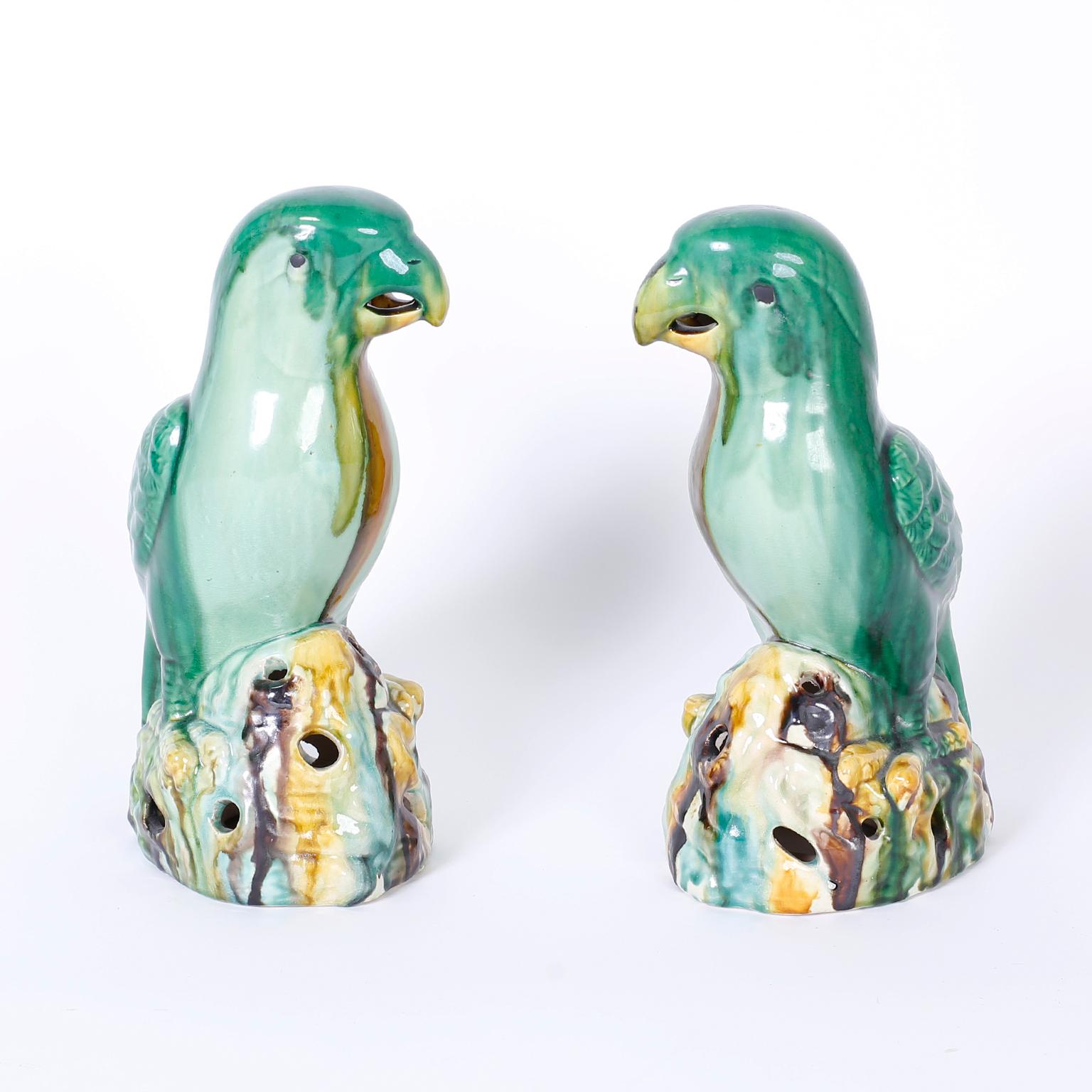 Intriguing pair of Chinese earthen ware birds or parrots glazed with greens, browns and creamy whites. The Sancai colors and glazing or slip technique is associated with the Tang dynasty and is well represented here.