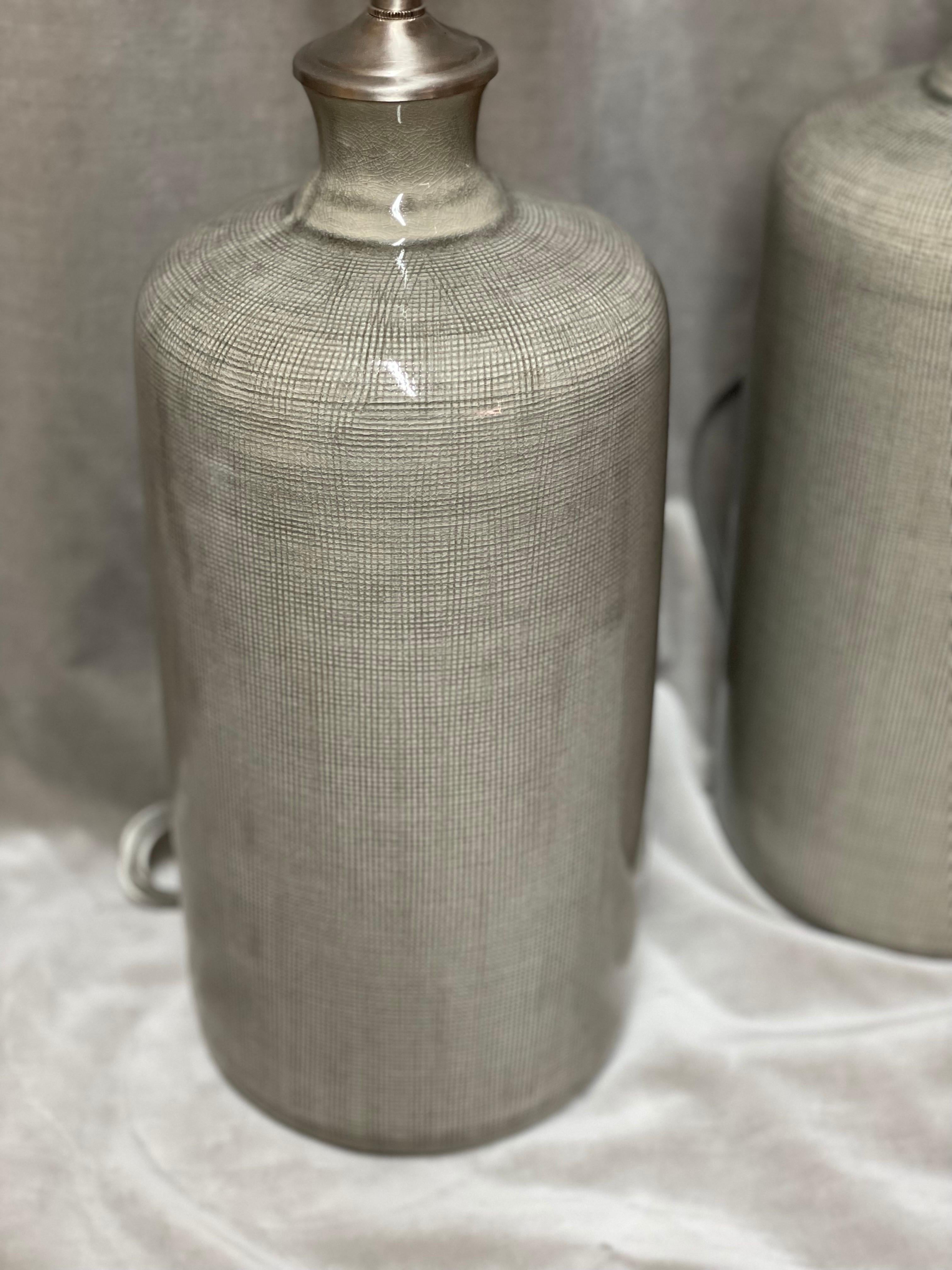 Great tall gray textured ceramic vessels with lamp application. These lamps have a beautiful glaze in Celadon style. The depth of color and texture gives these lamps an amazing richness and style The newly wired lamps come with Dual, individually