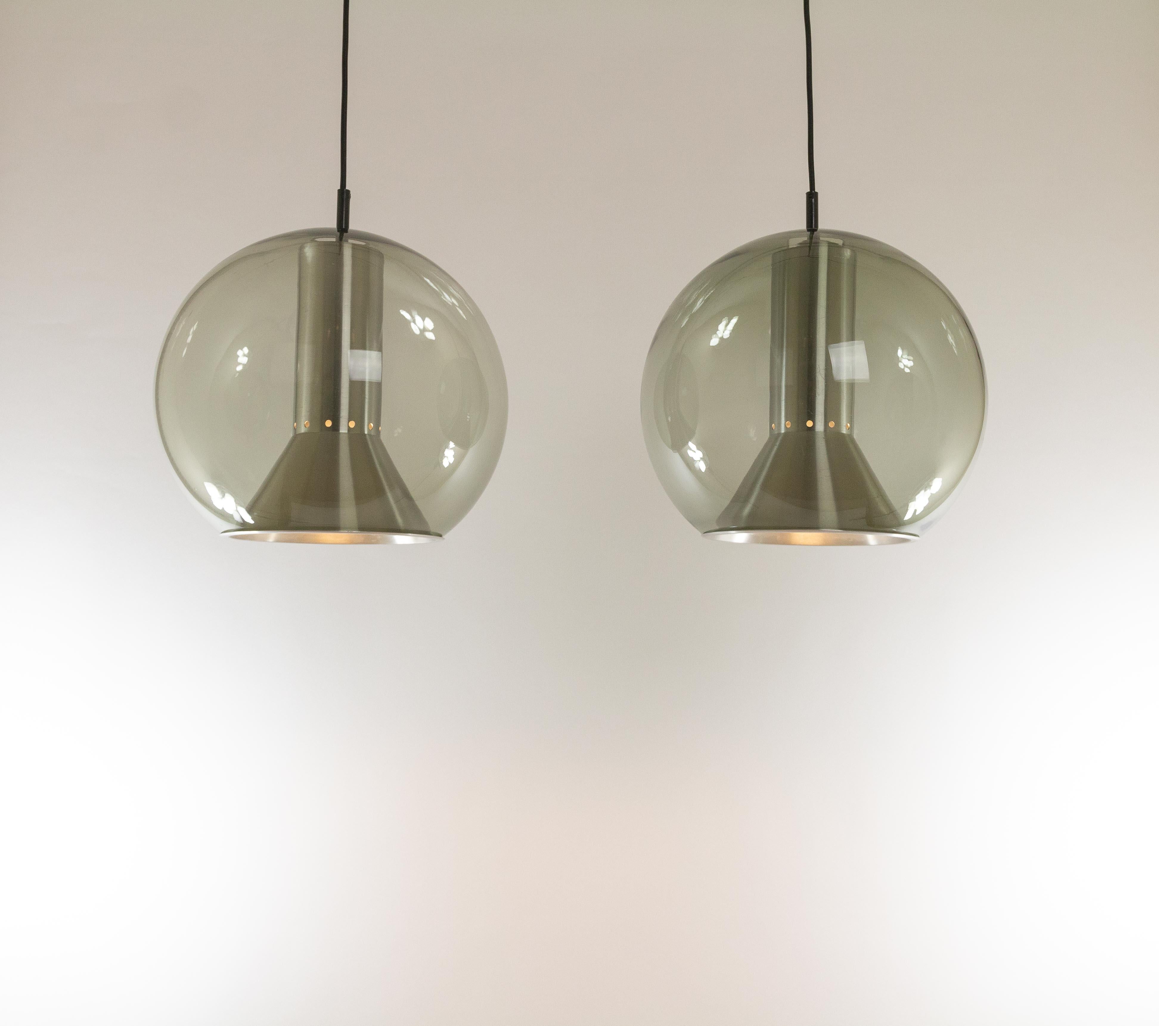 A pair of Globe pendants by Frank Ligtelijn for the Dutch lighting manufacturer RAAK Amsterdam, 1970s. 

This lamps are part of the so called Globe Series, consisting of the full range of potential models: desk, wall and floor lamps and a pendant
