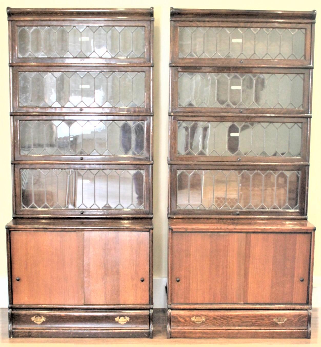 This pair of large stacking oak barrister's bookcases were made by the Globe-Wernicke Company of England in approximately 1920. These bookcases each have a set of four stacking bookcases with hand-crafted leaded glass door which lift up and slide