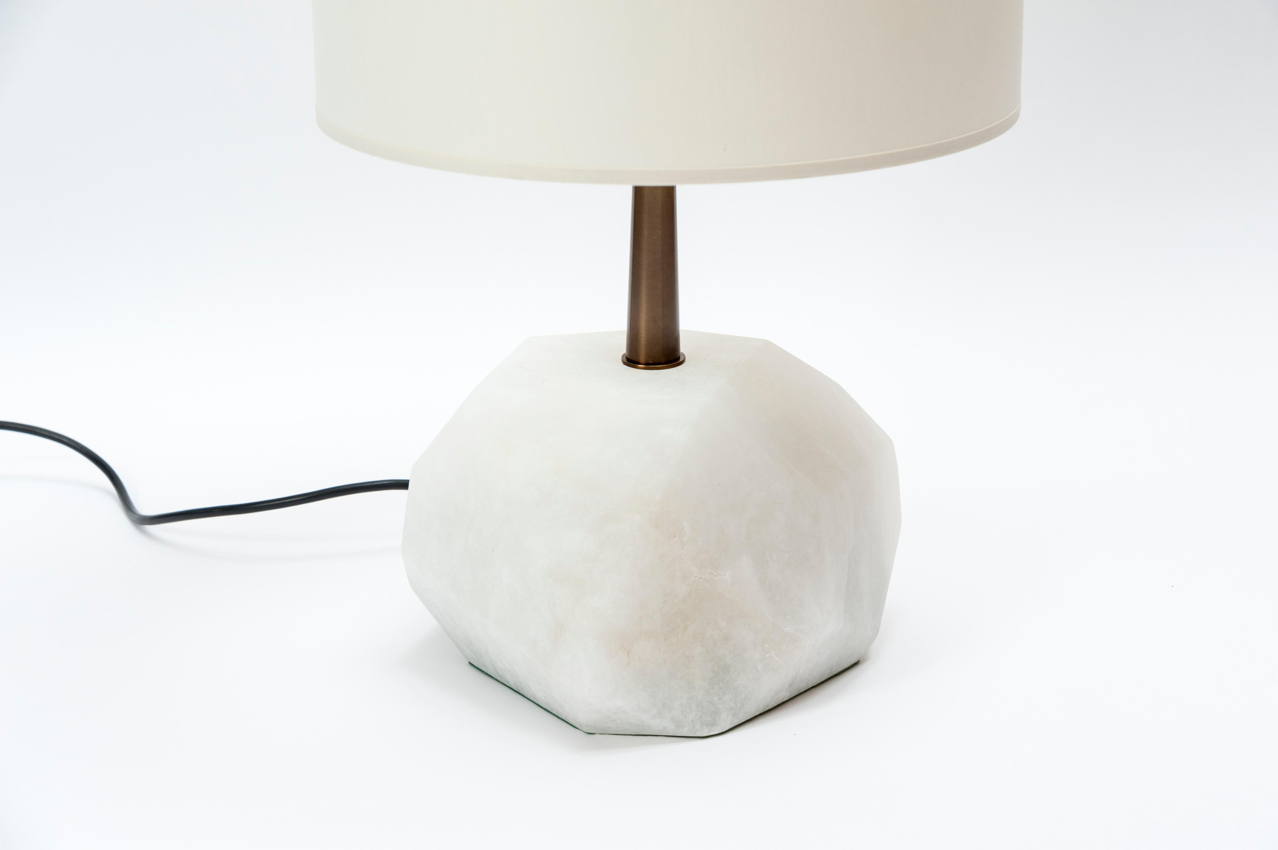 Creation table lamps by Glustin Luminaires.

Faceted block of alabaster topped with brass neck.

Light sources inside the alabaster and on top with independent switches.