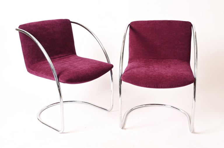 Marvellous midcentury pair of armchairs with tubular steel structure and plum fabric seats. 