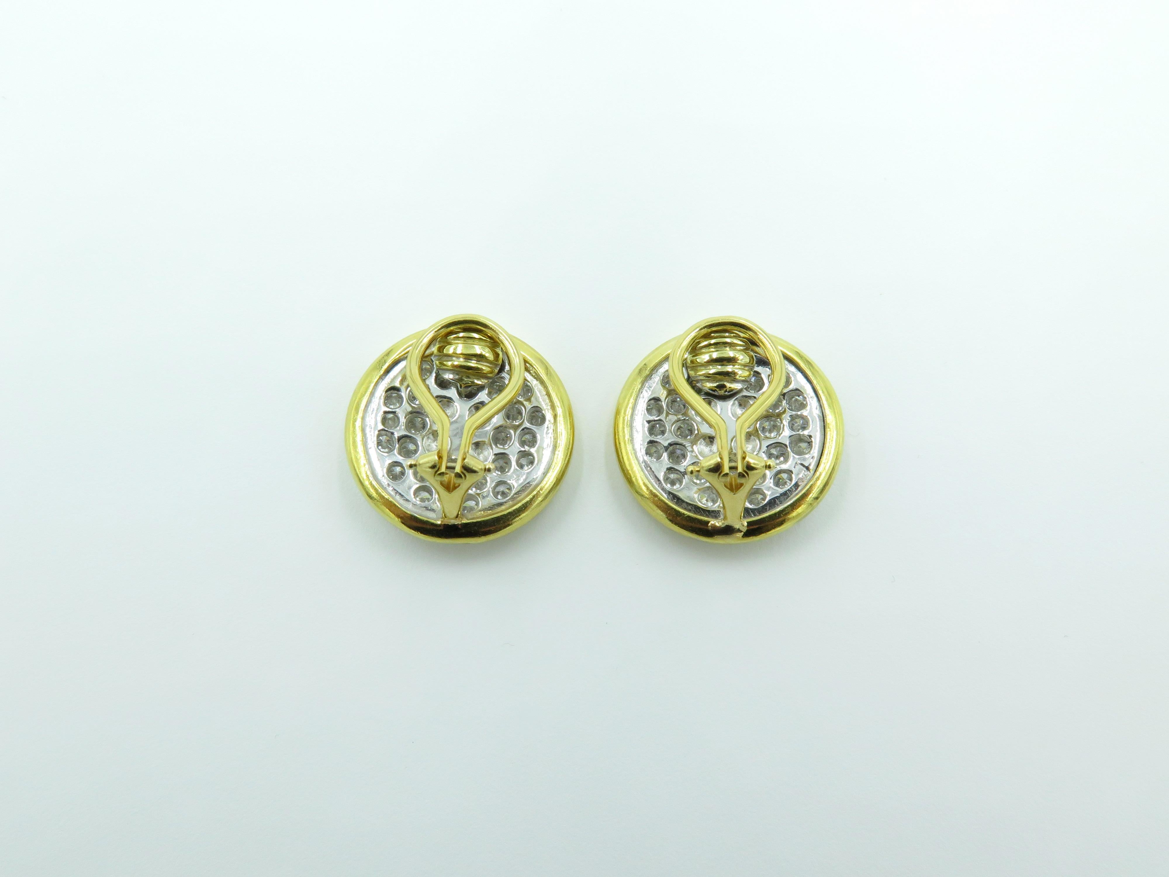 A pair of 18 karat yellow and white gold and diamond button earrings. Circa 1960.  Each round button pave set with diamonds, enhanced by a polished gold stitch. Fifty six (56) diamonds weigh approximately 2.50 carats. Diameter is approximately 3/4