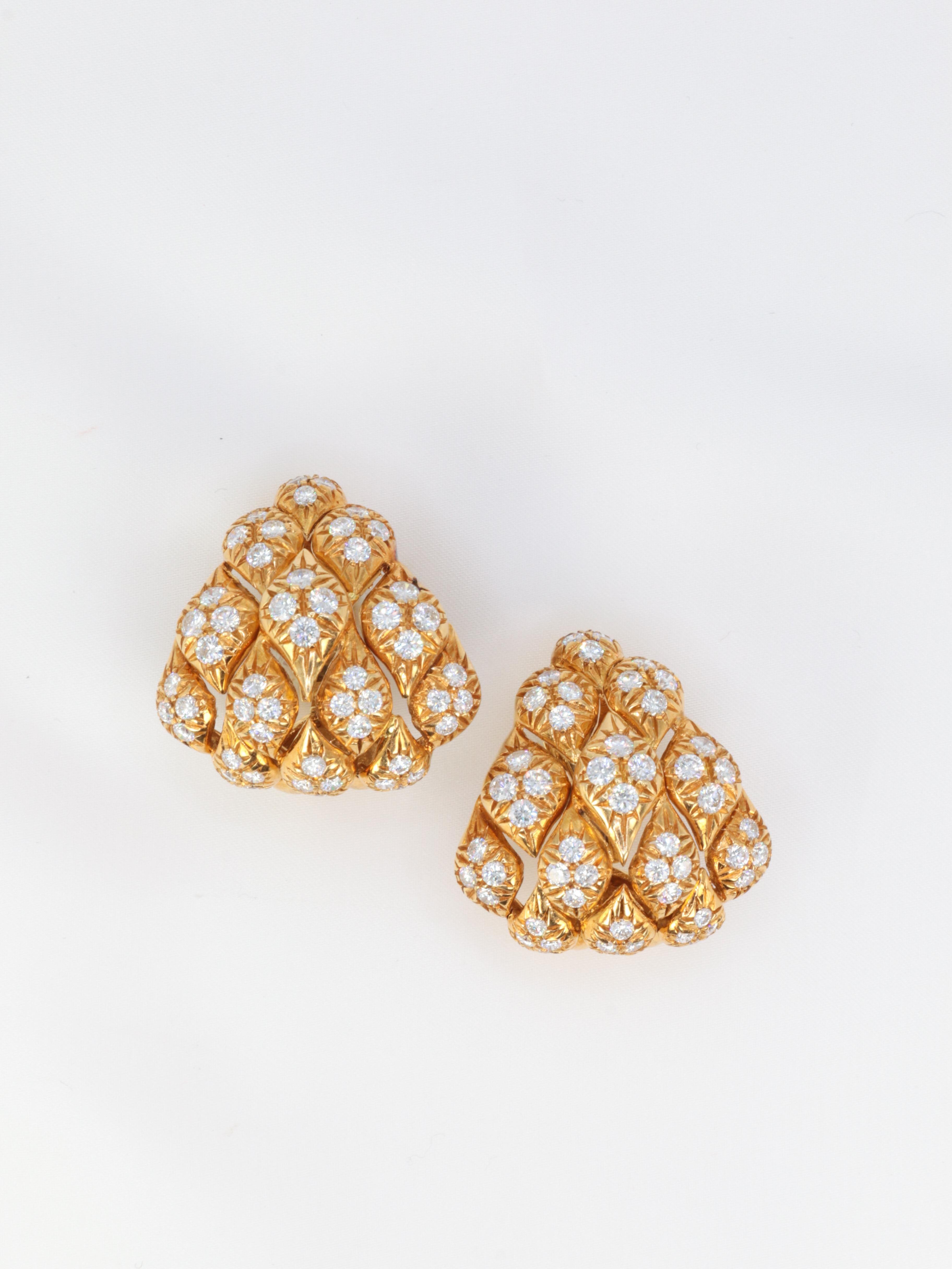 Pair of ear clips in 18k (750°/°°) gold and diamonds featuring a pine cone motif.
The scales of the pine cone are represented by lozenges in which are set, in star setting, four diamonds of excellent quality (DEF VS+) for a total weight of about