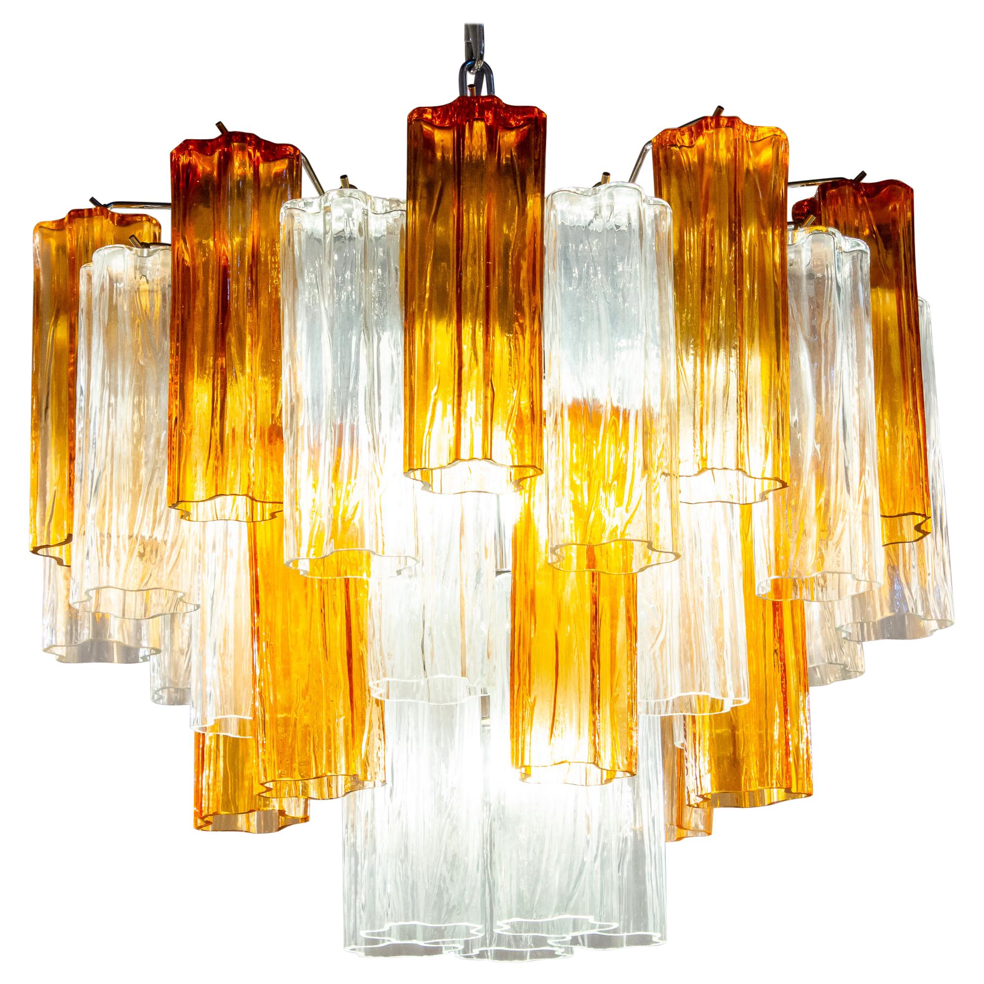 L'incredibile coppia di lampadari comprende preziosi vetri di Murano color oro e ambra e tronchi trasparenti lunghi 20 cm.
Struttura in metallo nichelato su tre livelli,
Condizioni vintage perfette.
Disponibili 8 lampadari e 4 coppie di