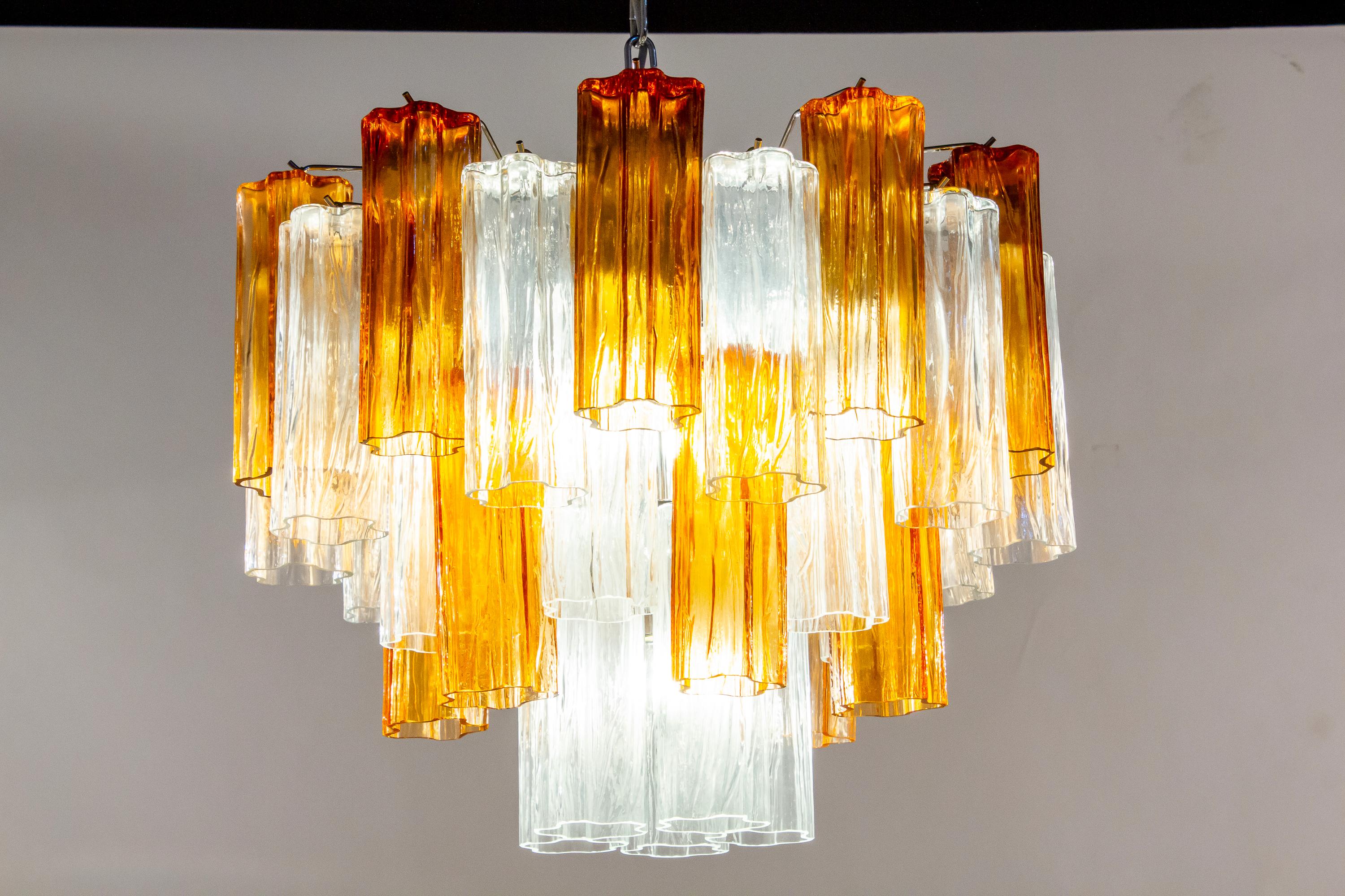 L'incredibile coppia di lampadari comprende preziosi vetri di Murano color oro e ambra e tronchi trasparenti lunghi 20 cm.
Struttura in metallo nichelato su tre livelli,
Condizioni vintage perfette.
Disponibili 8 lampadari e 4 coppie di