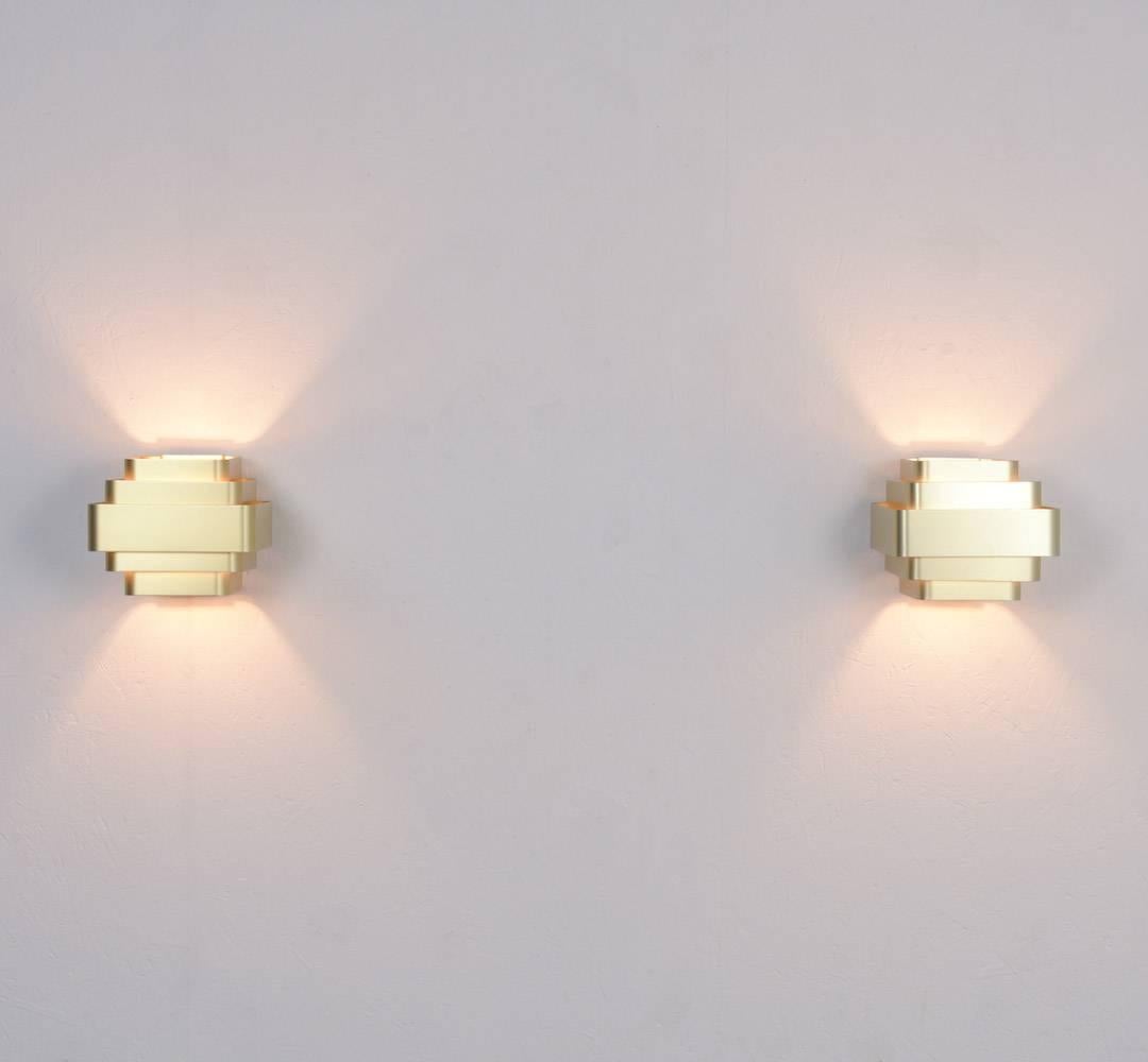 This beautiful pair of wall lamp was designed by the Belgian interior designer Jules Wabbes in the late 1960s.
The five gold colored aluminium strips diffuse the light.
Both lamps are in perfect vintage original condition, one lamp is a little