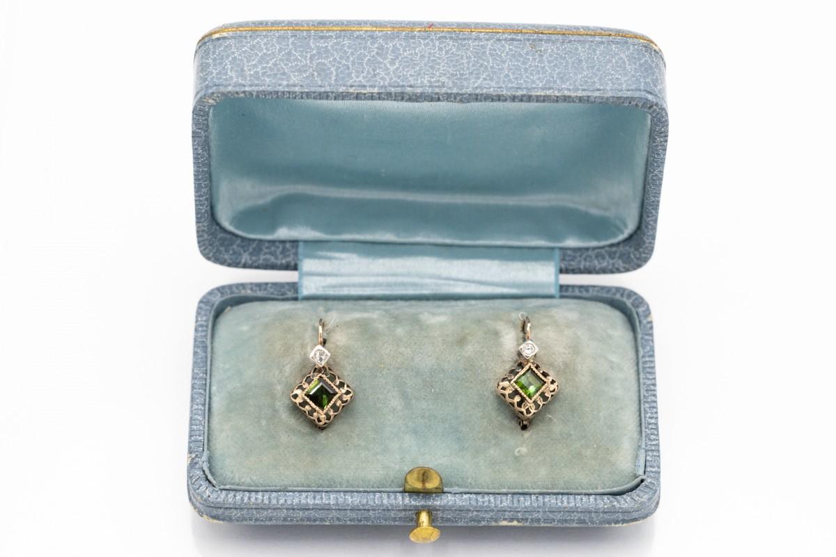 Un paio di orecchini d'oro con tormaline verdi del peso di 0,40ct e piccoli diamanti del peso di 0,03ct.
Incastonato in oro giallo 14 carati 
Origine: Ungheria, 1937-1966 (marchio conservato)
Peso del prodotto: 2,28 g
Lunghezza: 16 mm.
Ottime