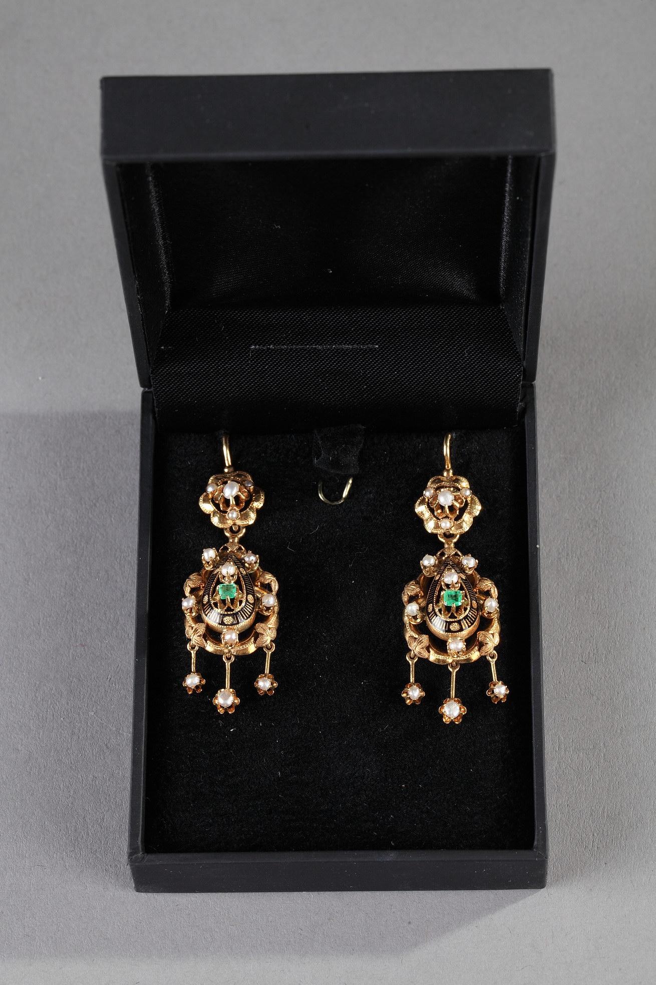 Pair of pendant teardrop earrings in yellow gold sculpted with leaves and inset with pearls. Three pendants with pearls hang from each teardrop. In the center of each earring is a smaller teardrop accented with black enamel and inlaid with a pearl
