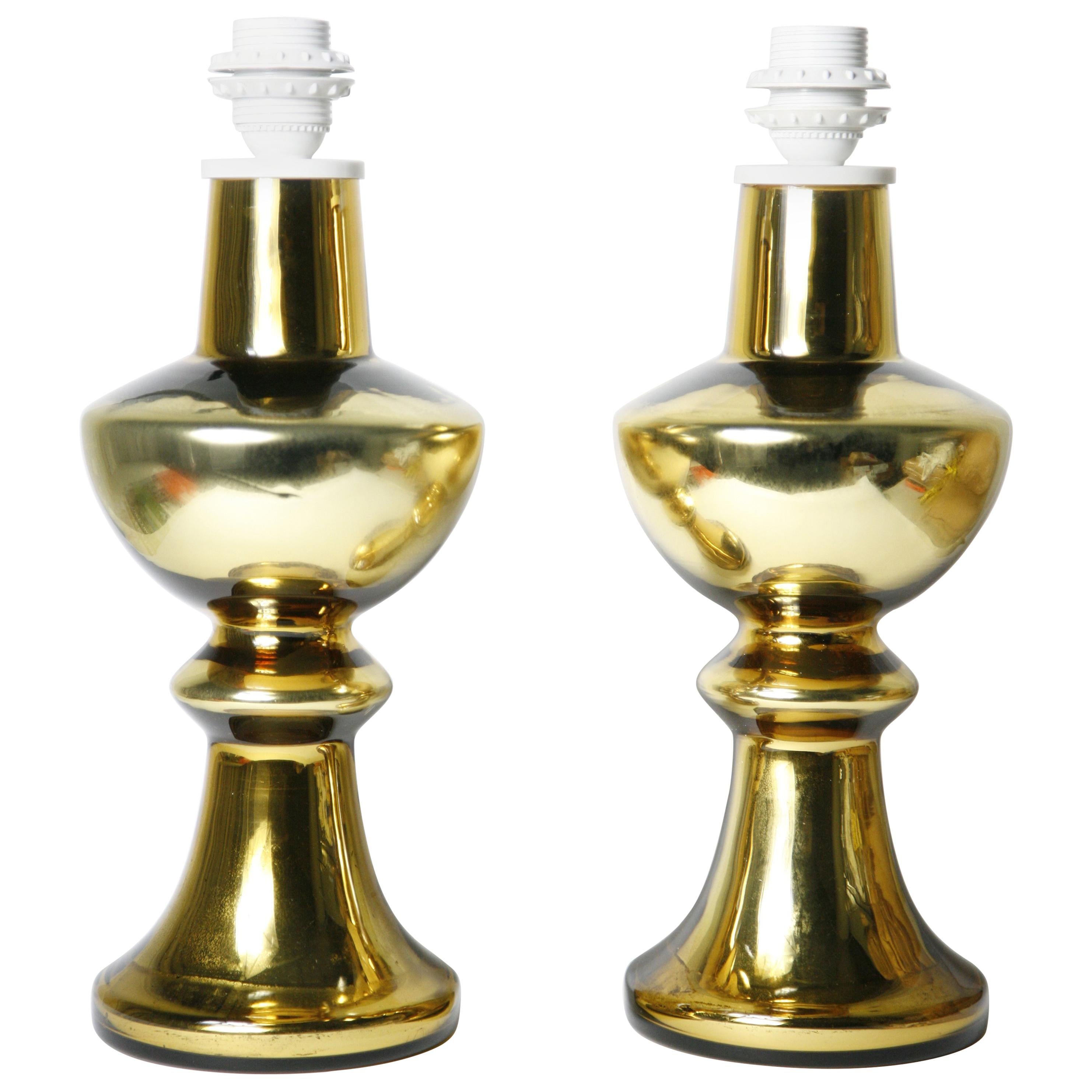 Pair of gold glass cased table lamps by Flygsfors Sweden, 1970.
This Flygsfors pair has a similar patina to each other on the inside of the glass that gives them a rustic character to them the light will reflect on the gold bases and give a warm