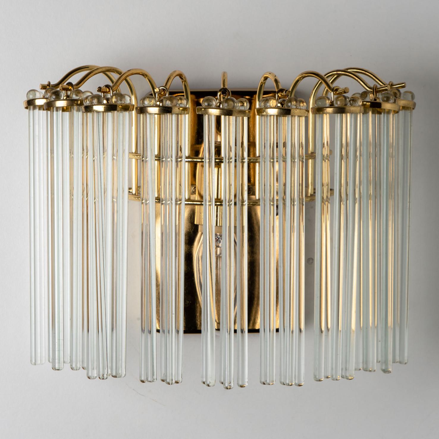 Pair of Wonderful high-end wall sconces in the style of Sciolari. With long hanging glass 'tubes' and brass details giving this piece an elegant appearance which refracts the light, filling a room with a soft, warm glow.
The wall sconce has a brass