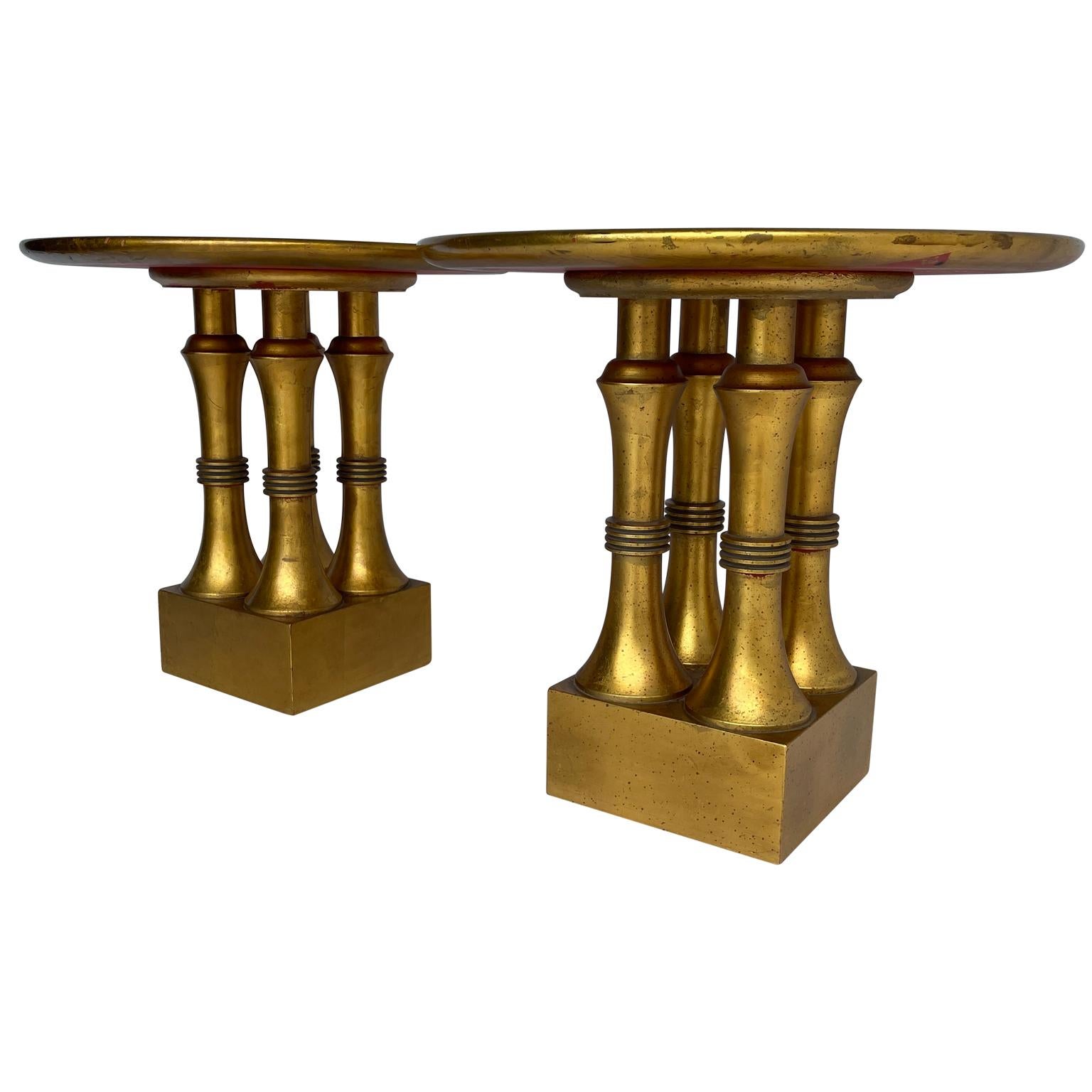 This pair of round end tables are American made, Circa 1950. The sweet tables are covered in gold leaf over a red lacquer base. The columns are carved, balancing a nice square base. Round and low profile, these tables have so many uses; bedside