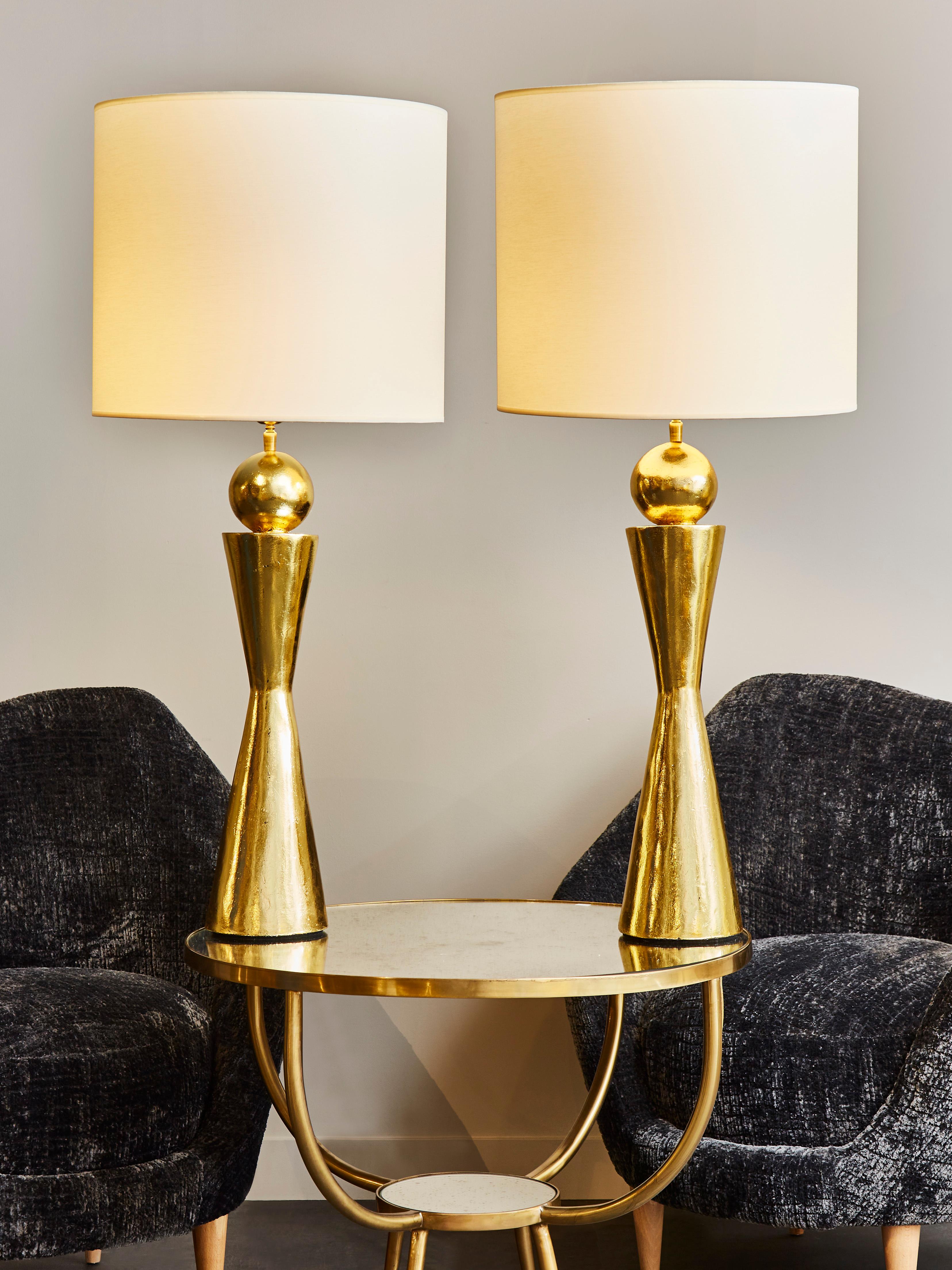 Pair of beautiful tall table lamps made of plaster covered with gold leaf.