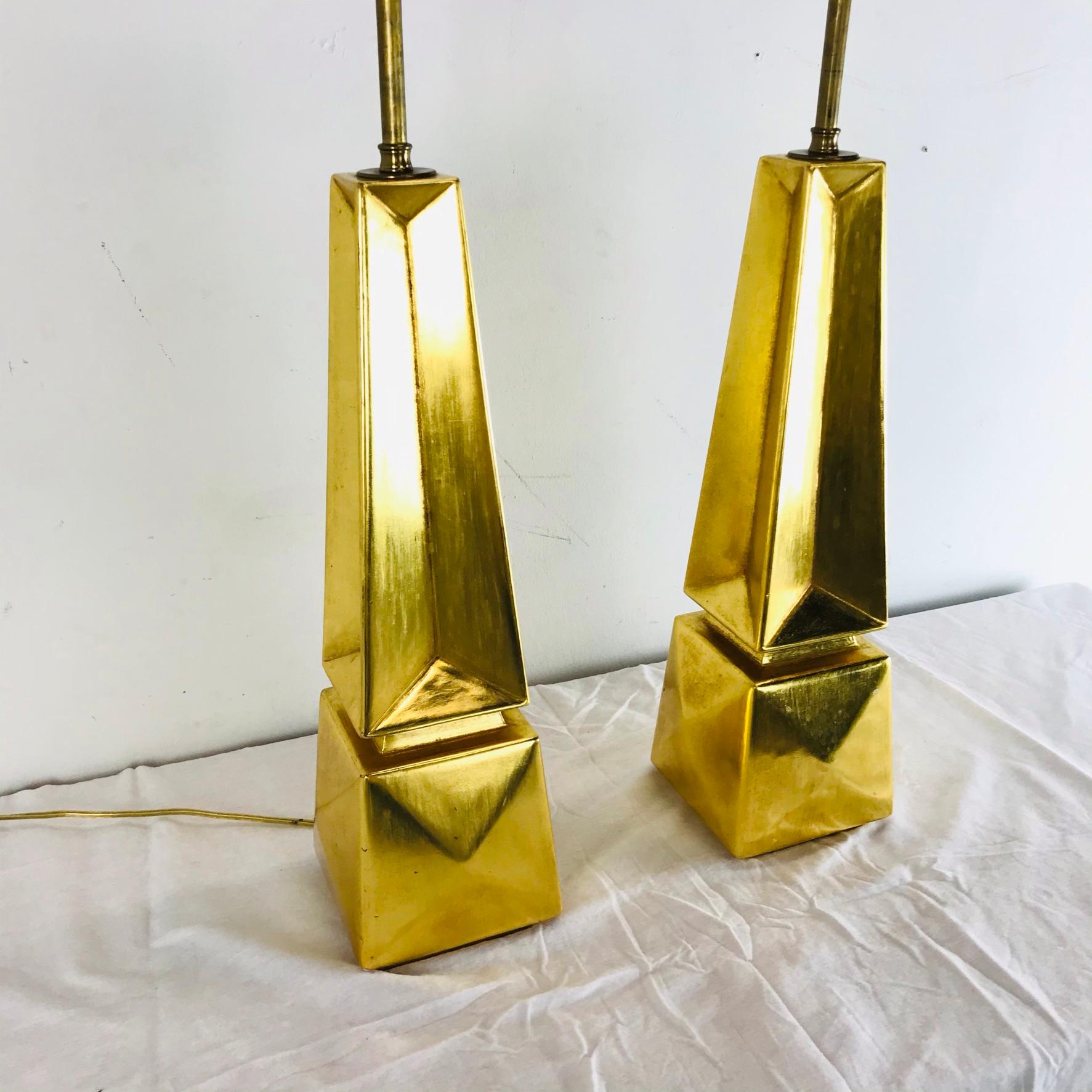 The breathtaking gold tone and geometric shapes of this set of two obelisk table lamps will add sophistication and opulence to any room. Height is adjustable.