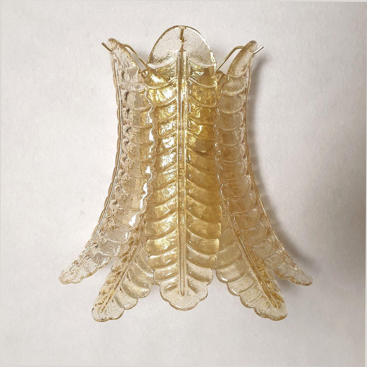Paar Mid Century Modern Murano Glas Wandleuchten, im Stil von Barovier Italien 1980er Jahre.
Das Paar Wandleuchter besteht aus einem Messingrahmen und Murano-Glasblättern mit echten Goldeinschlüssen.
Das Gold macht das Murano-Glas lichtdurchlässig