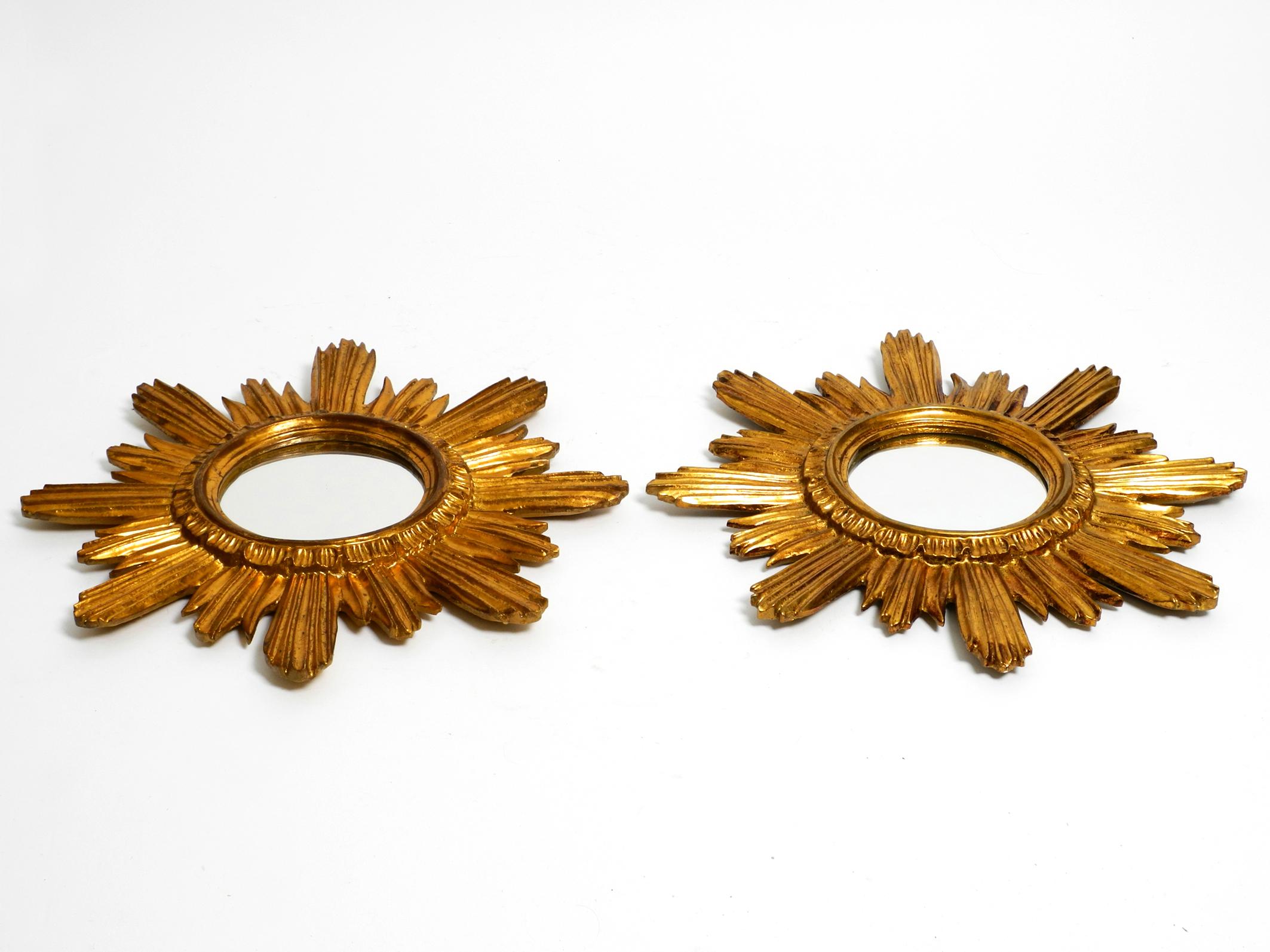 European Pair of gold-plated mid-century sunburst wall mirrors made of wood and resin For Sale