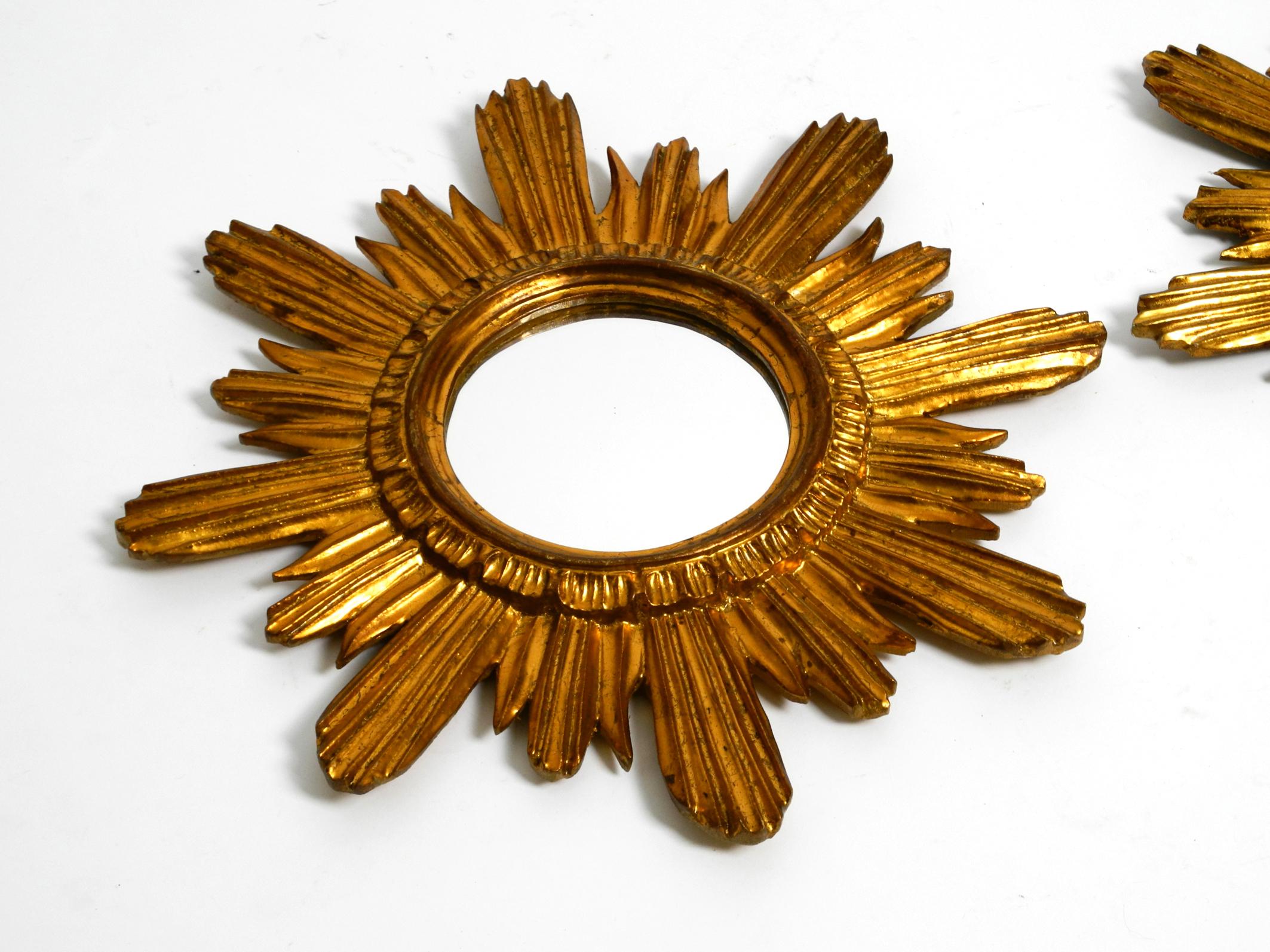 Mid-20th Century Pair of gold-plated mid-century sunburst wall mirrors made of wood and resin