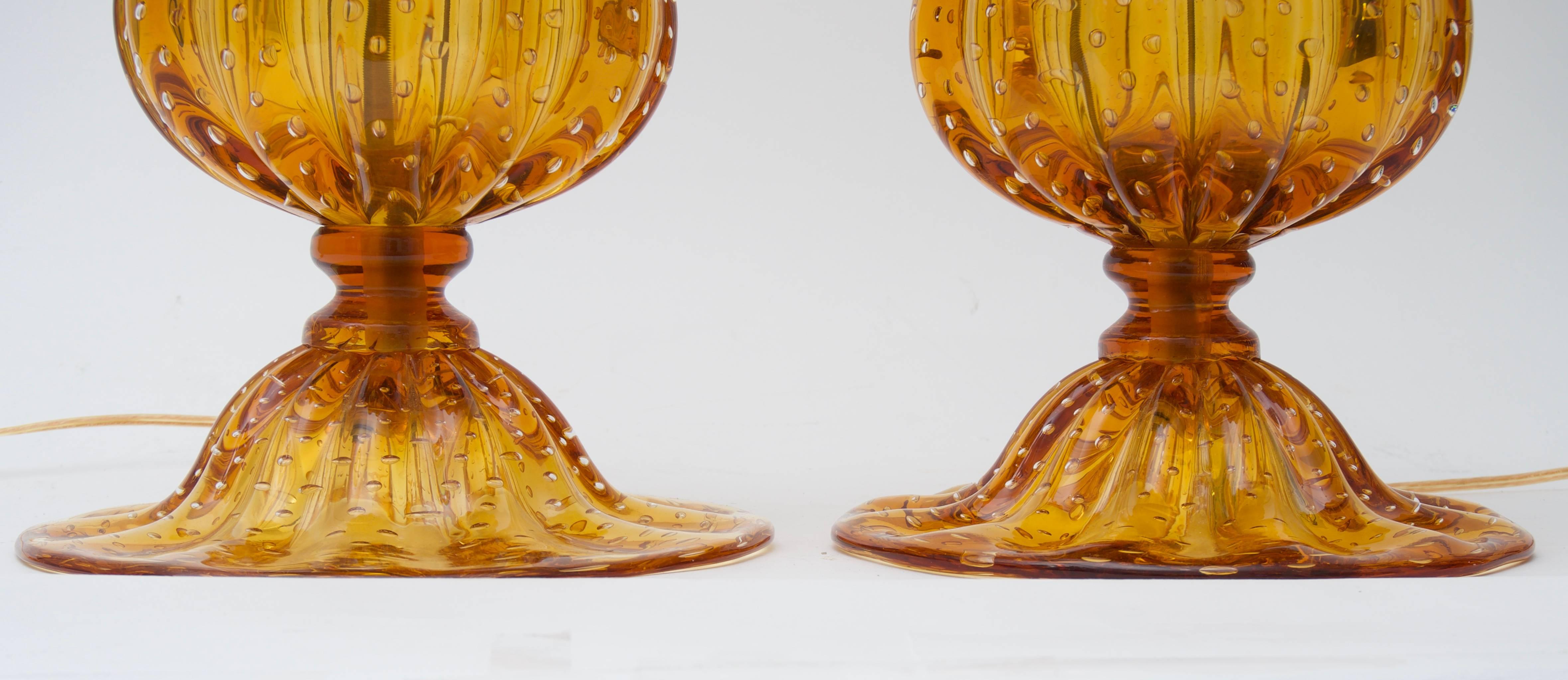 Cette paire de lampes en verre de Murano de grande taille date de la fin du 20e siècle et a été créée par l'artisan verrier Alberto Donà. Les pièces sont d'une coloration dorée profonde selon la technique du Bullicanti (bulles contrôlées). 

Note :