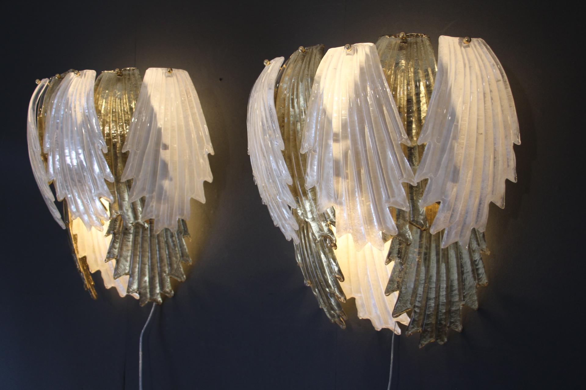 This spectacular pair of wall lights was entirely handcrafted in Murano. Each single leaf was individually made in high quality blown glass, this is why we can notice very light difference from a piece to another. Its gold color was made thanks to