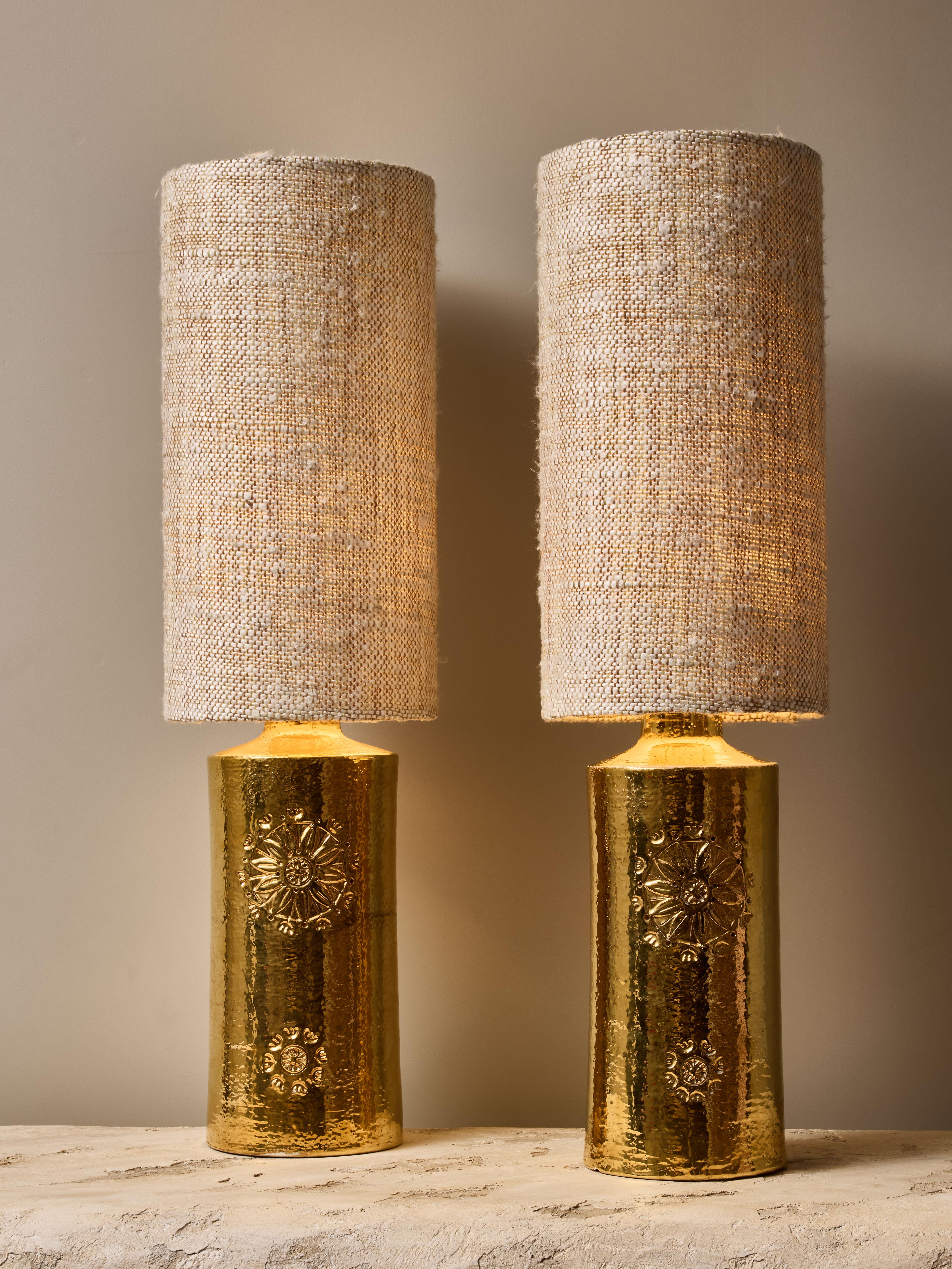 Paire de lampes de table cylindriques en céramique, avec une glaçure dorée brillante et des décors floraux sculptés.

Autocollant original de la  sous les lampes.

Dimensions avec abat-jour : ø20 H73cm.



BERGBOMS
Bergboms est une entreprise