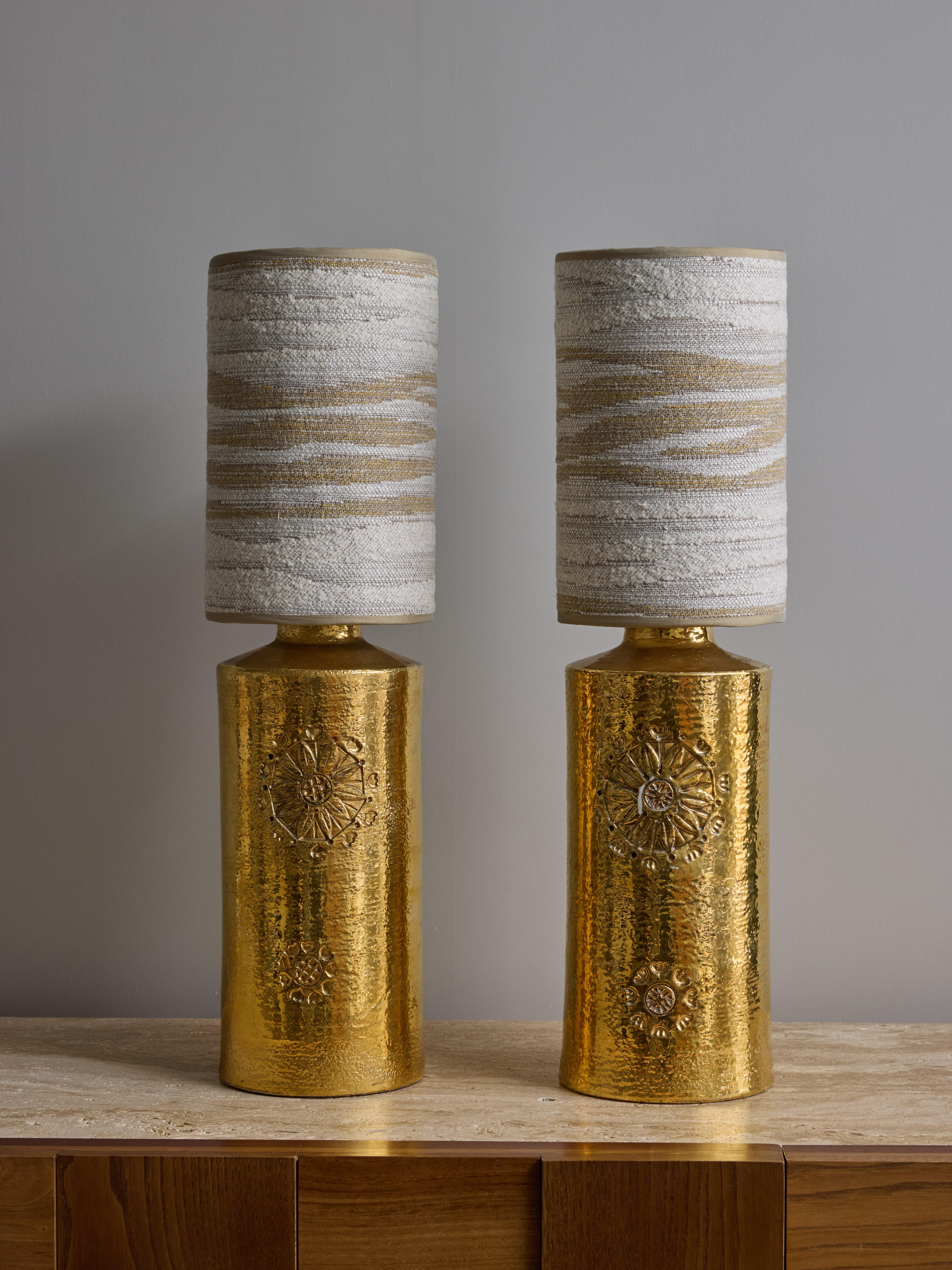 Pair of cylindrical ceramic table lamps, with a shiny gold glaze and carved flower decors.

Original sticker of the manufacturer under the lamps.

Dimensions with shades: ø15 H57cm.



BERGBOMS
Bergboms is a Swedish lighting company that has been