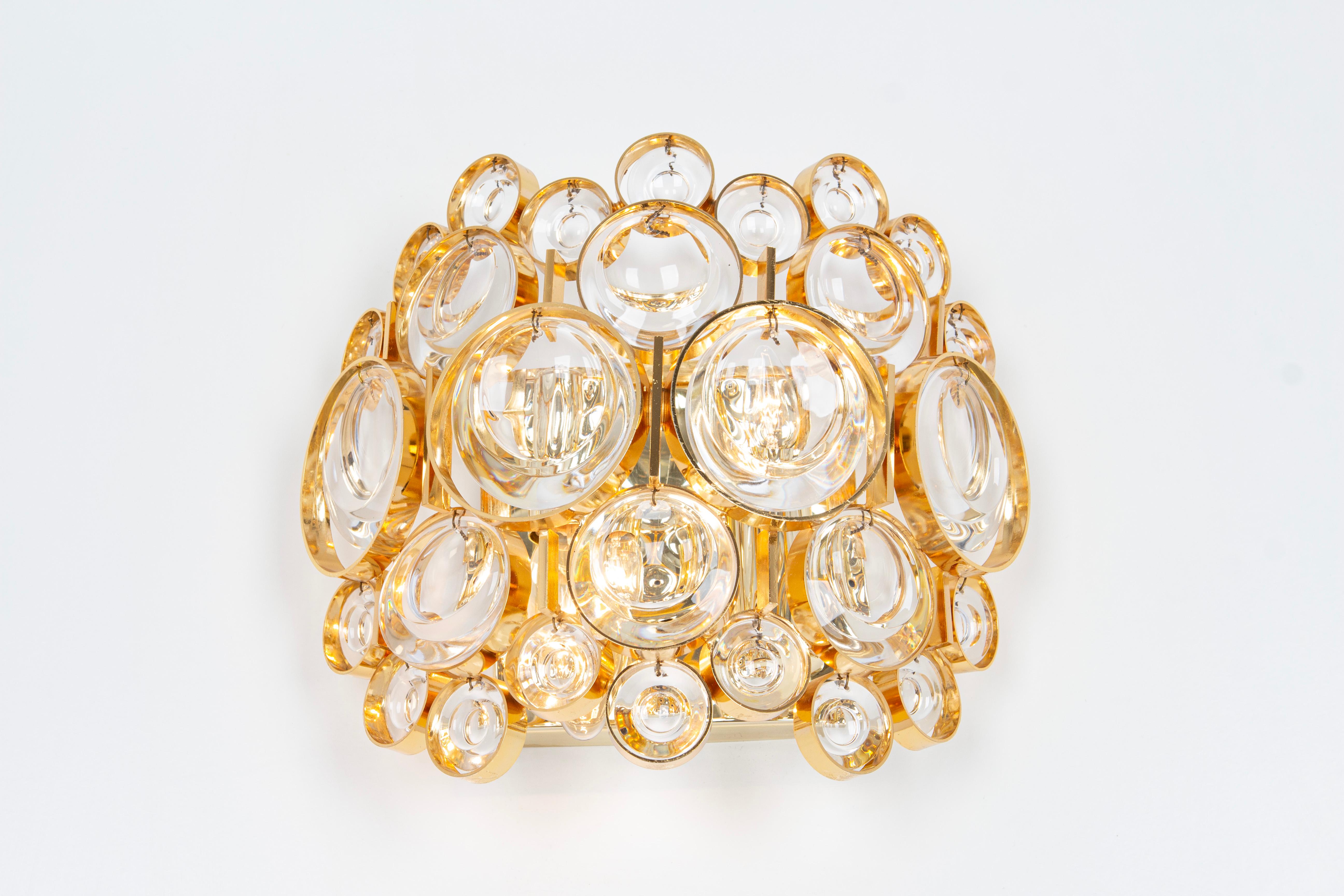 A stunning golden sconce, made by Palwa, Germany, circa 1960-1969. Crystal glasses on a gilt brass frame.
Best of the 1960s from Germany.
High quality and in very good condition. Cleaned, well-wired and ready to use.
Each Scounce requires 2 x E14