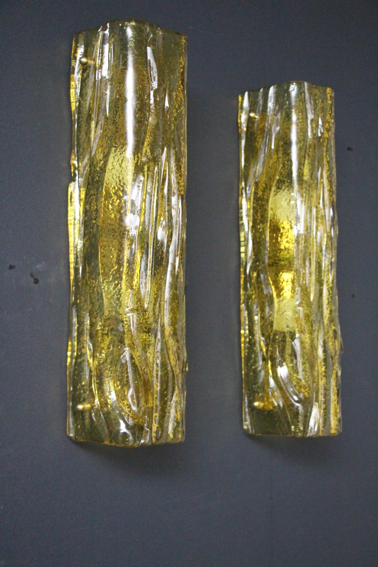 Cette très belle paire d'appliques a été conçue et réalisée individuellement à Murano . Ces appliques présentent de belles formes de tubes carrés avec de nombreux détails, comme les paillettes dorées capturées dans le verre.
Leur forme est simple et