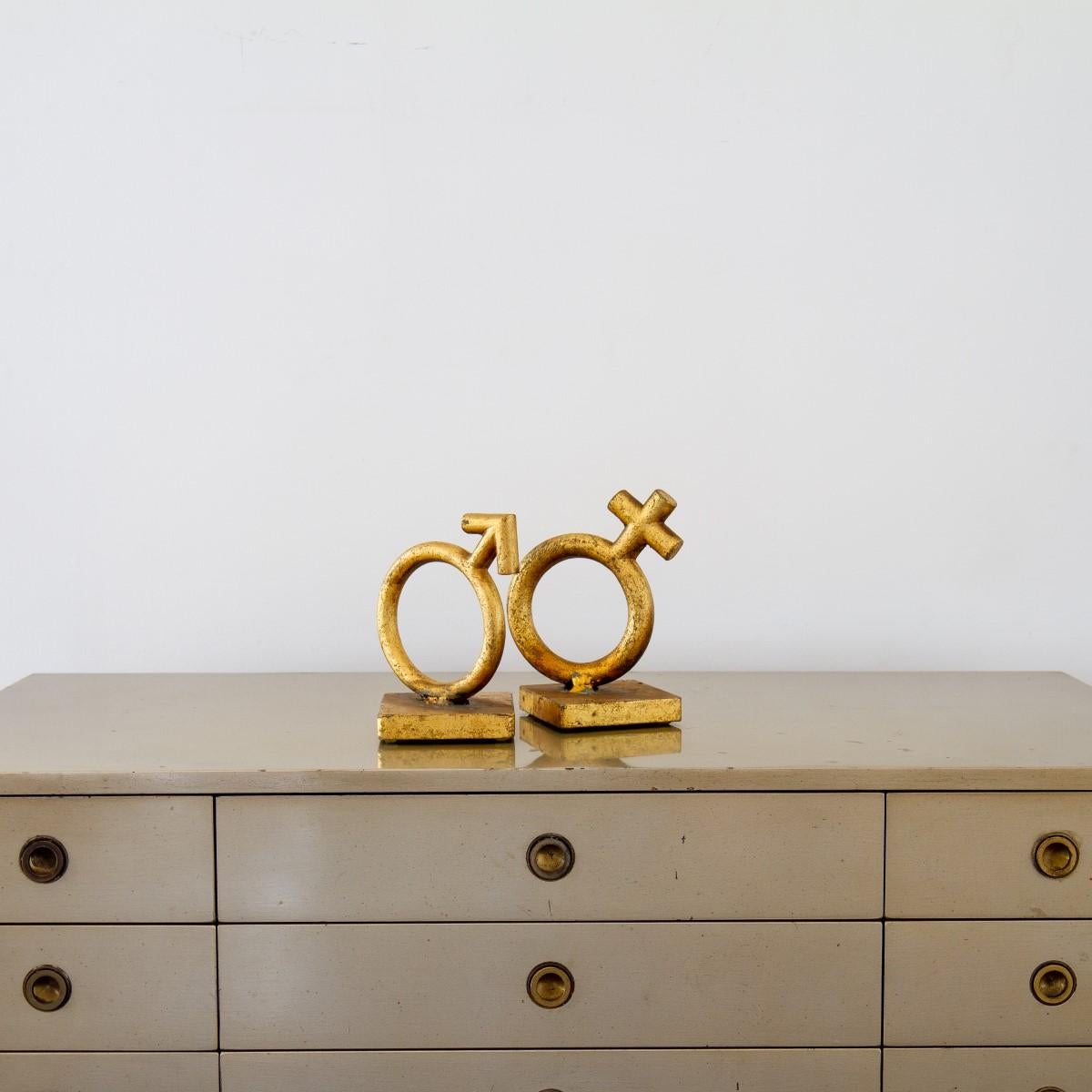 A matched pair of gold leaf cast metal bookends depicting the Mars and Venus gender symbols by Curtis Jere signed and dated 1970.

Curtis Jeré is the collaboration of two metal sculptors Jerry Fels and Curtis Freiler who founded the company