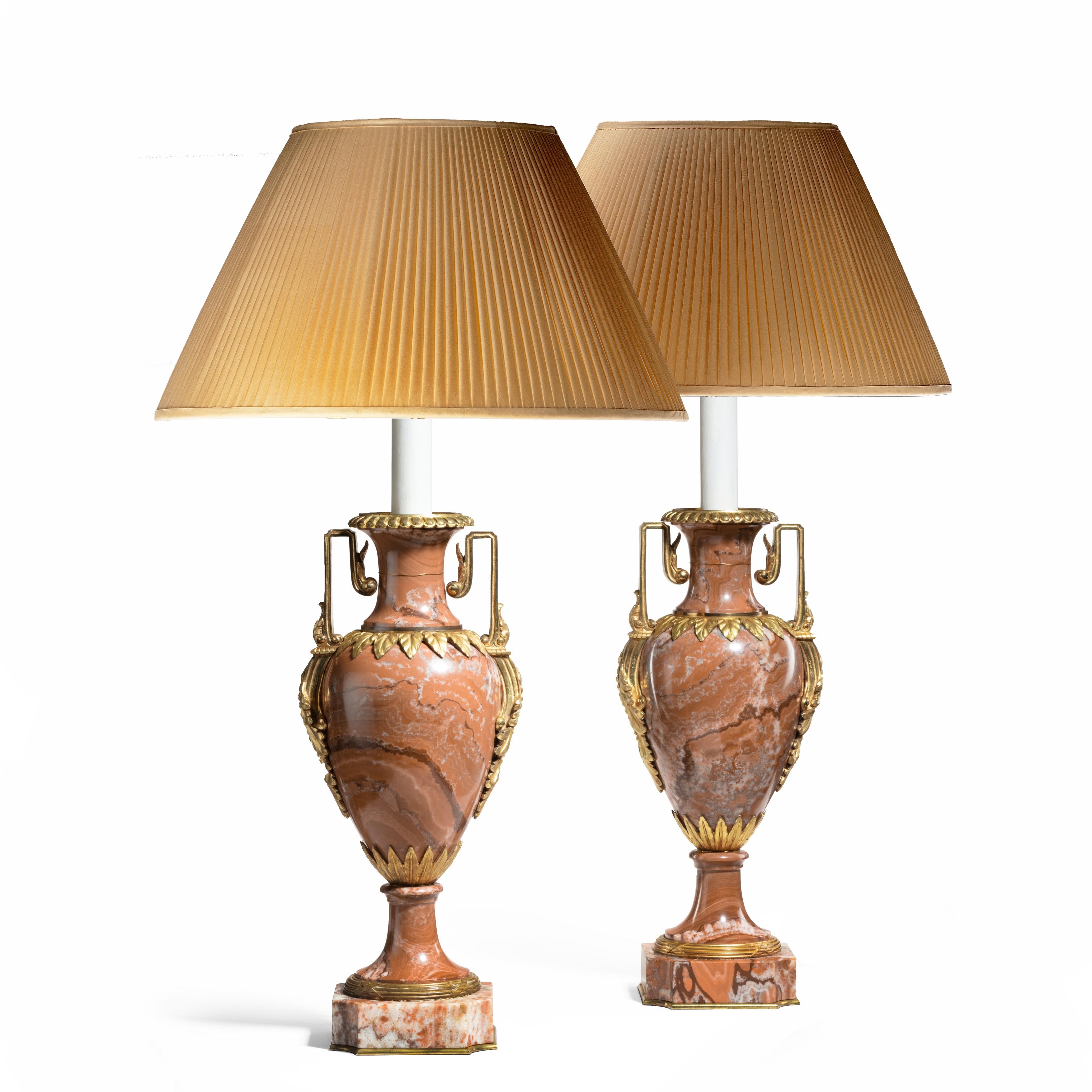 A pair of good Napoleon III rouge marble vases, each mounted in ormolu with a pair of square bracket handles and collars of pointed leaves, now fitted for electricity. French, circa 1870 (shades not included).
 