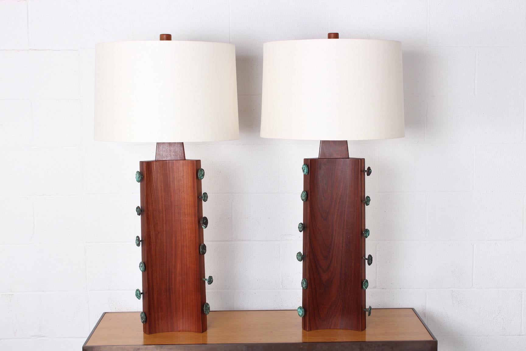 A pair of large-scale walnut lamps with bronze studs and walnut finials. Designed by Gordon Martz.