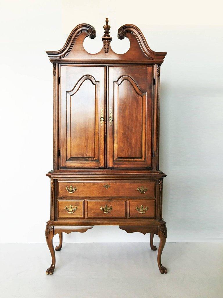 Absolutely gorgeous and wonderfully proportioned cabinets. This mahogany stained piece features a broken scroll pediment with a central finial. Two paneled doors open to two shelves complete the top half. The lower base features a full width drawer