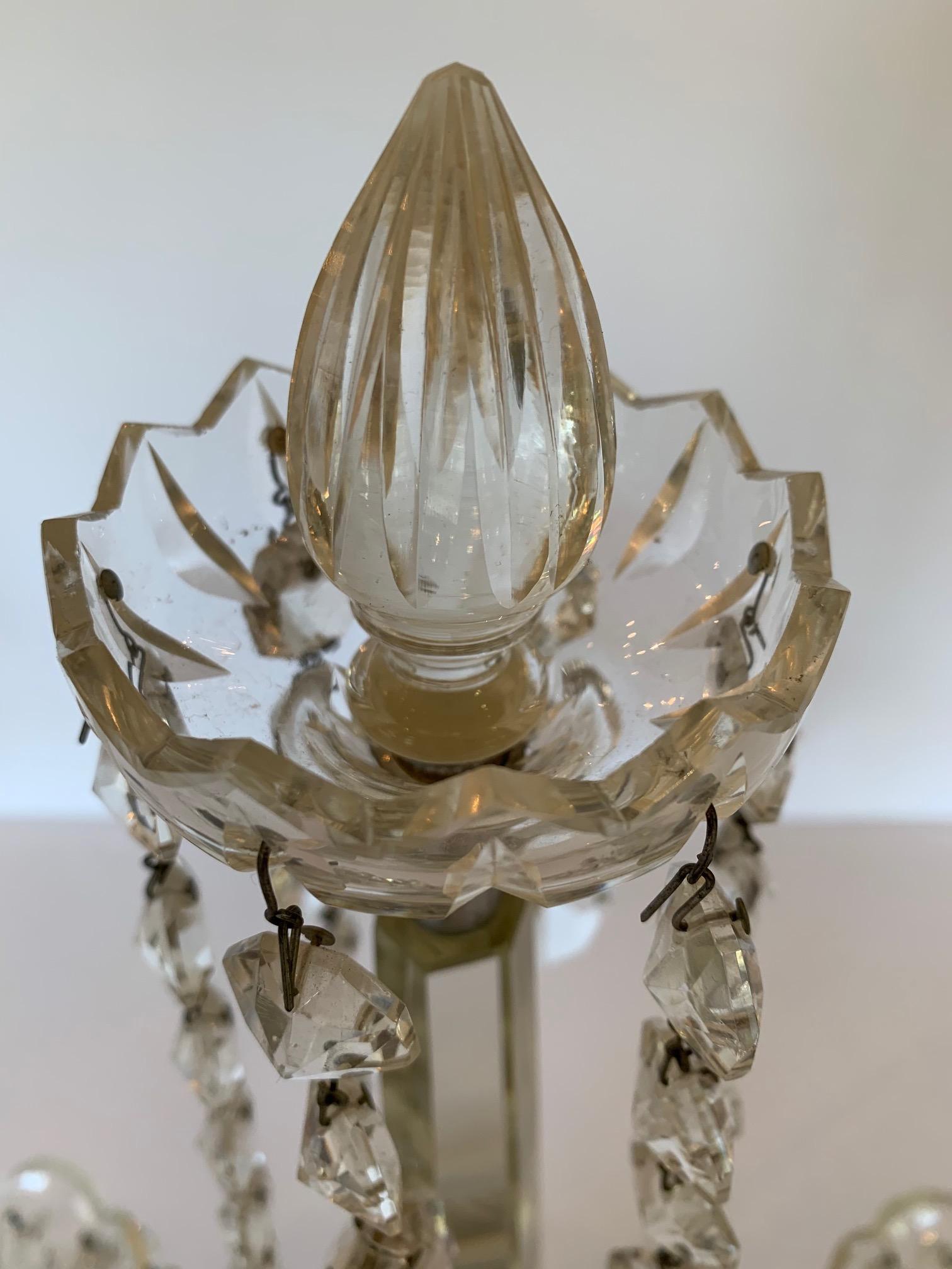 A pair of crystal two branch candelabra with drop prisms, center part has crystal sphere with 4 crystal beaded garlands and a square crystal base.