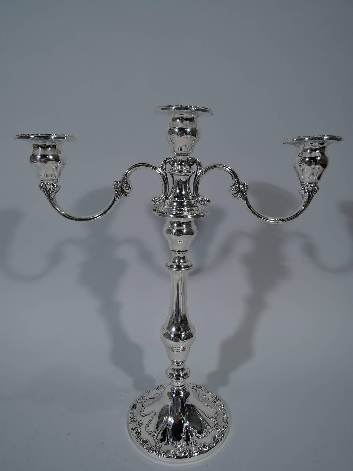 Pair of sterling silver three-light candelabra in Chantilly pattern. Made by Gorham in Providence. Each: Raised foot, baluster stem on knop, terminating in central socket mounted with two double-scroll arms, each terminating in single socket. Raised