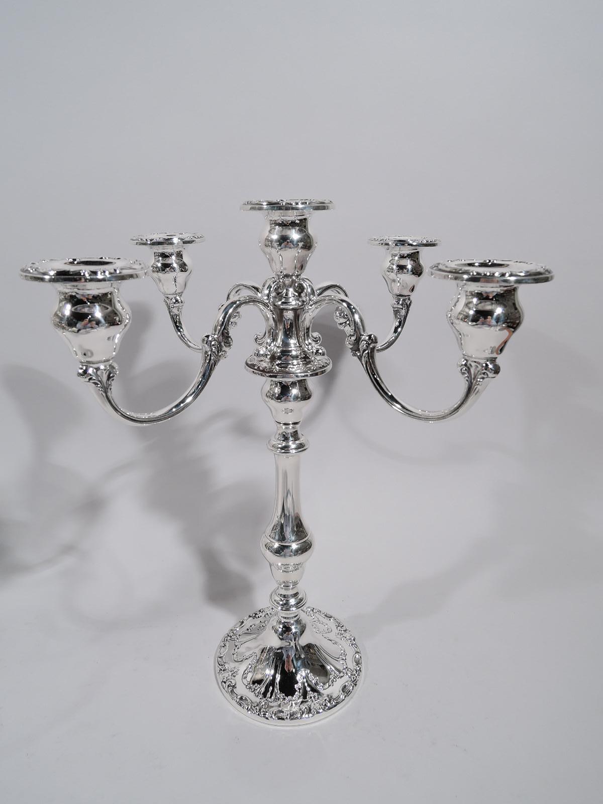 Chantilly sterling silver 5-light candelabra. Made by Gorham in Providence. Each: Baluster shaft on raised foot; raised central socket and 4 S-scroll arms, each terminating in single socket. Sockets bellied urn. Applied scrolls and garlands. A