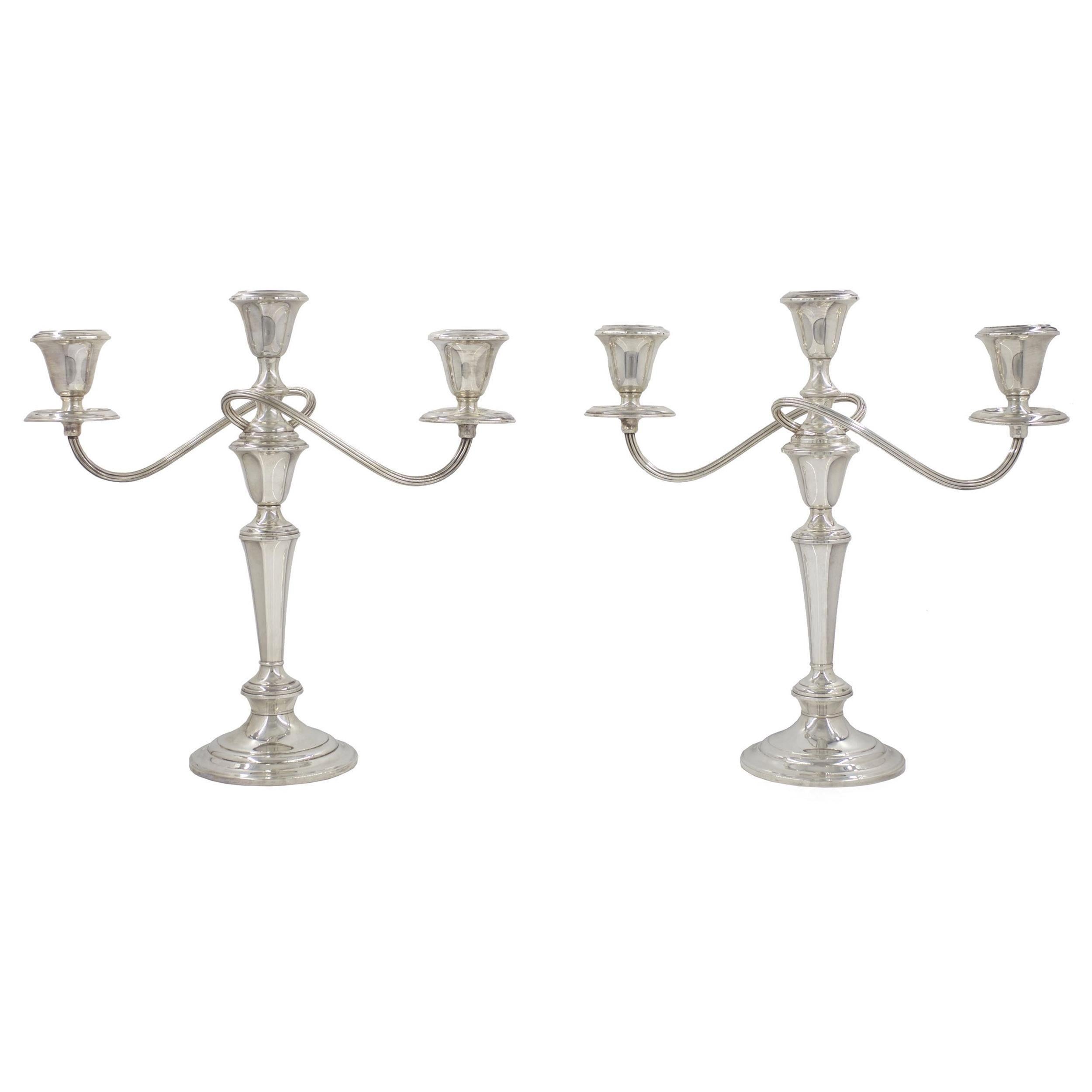 An exquisite pair of vintage weighted sterling silver candelabra from the iconic American firm Gorham Co., they feature a stunning swirled-and-reeded stem that completely wraps around the central candlewell. They are convertible into simple