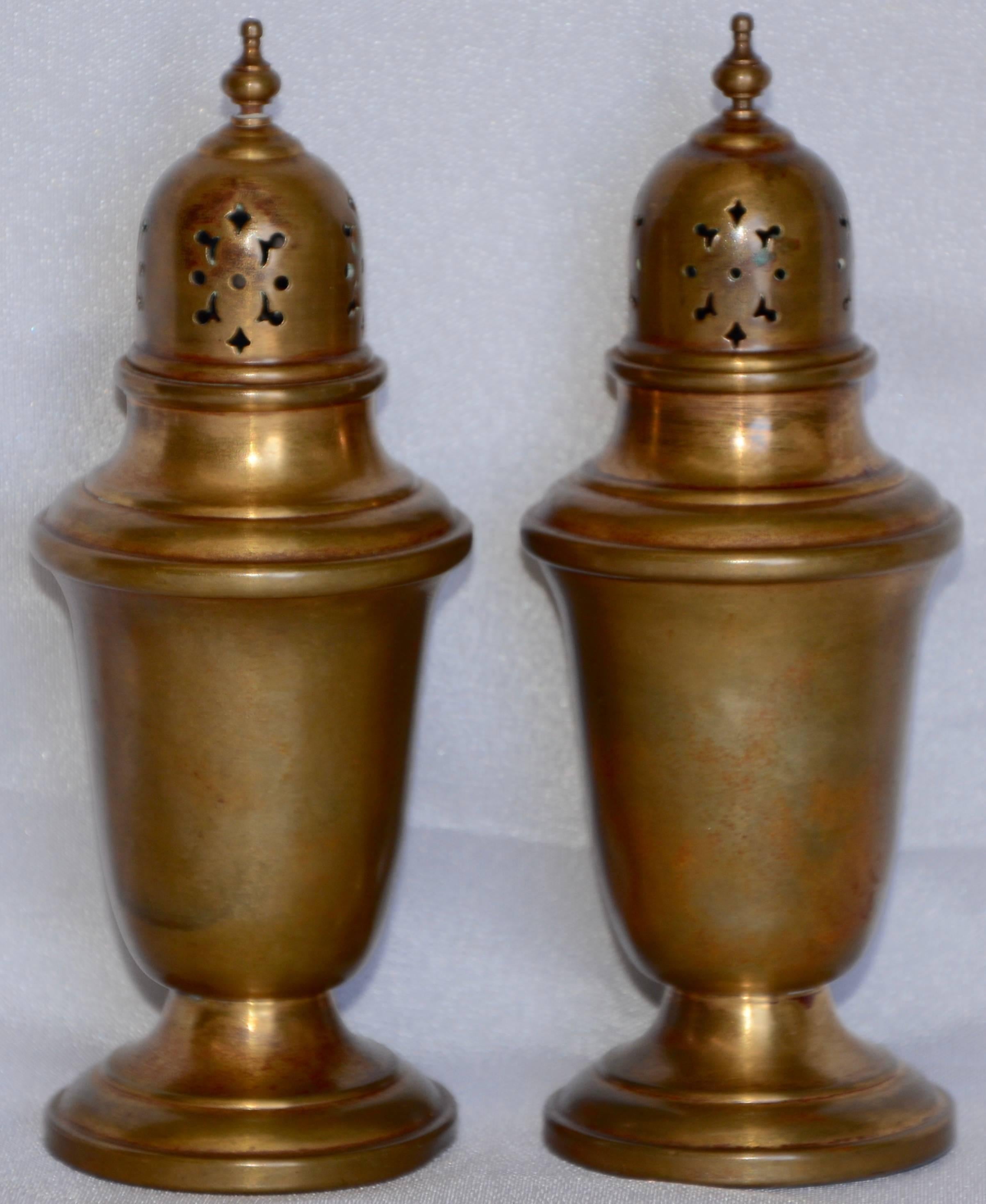 This is a nice pair of copper salt and pepper shakers with a brass finish. They are by Gorham Giftware and are marked L27. They have delicate cutouts on the top to dispense the condiments and are topped with tiny finials.