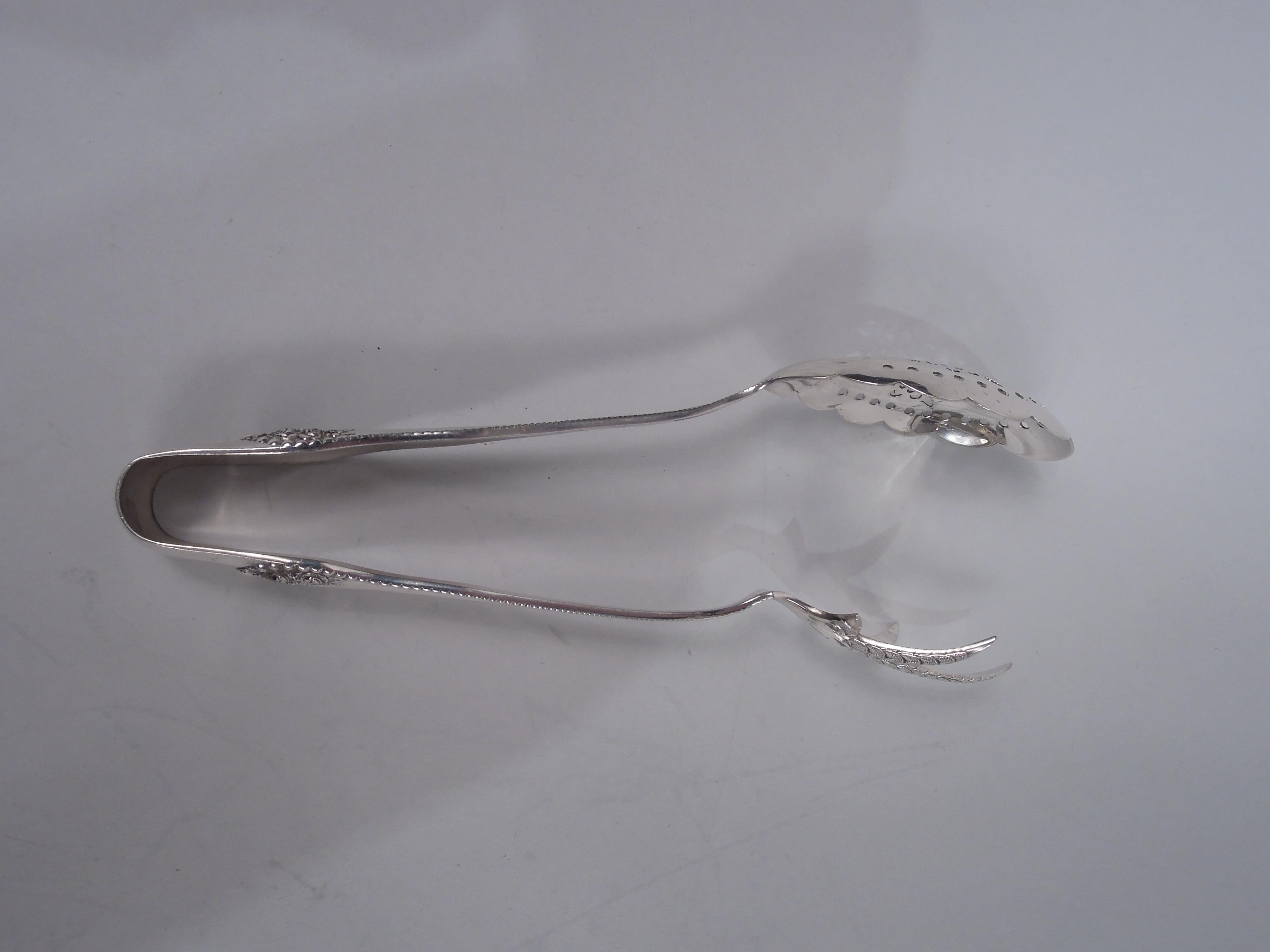 Pair of Lancaster sterling silver ice tongs. Made by Gorham in Providence, ca 1900. U-form with beaded stem and floral terminal. One jaw ovoid and scalloped with ornamental piercing; the other a cast claw with five talons. A nice early piece in this
