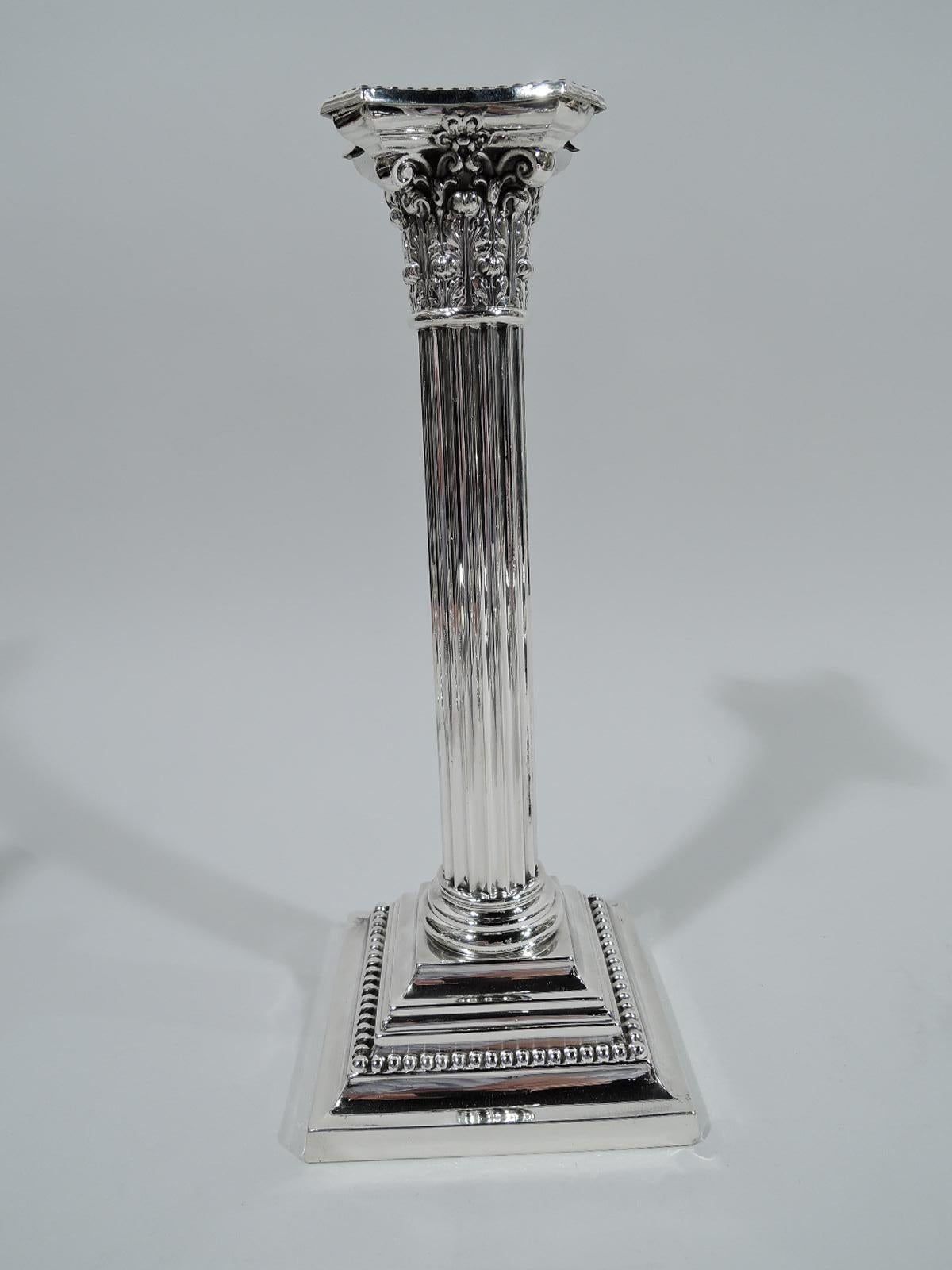 Pair of classical sterling silver candlesticks. Made by Gorham in Providence in 1947. Each: Fluted column and composite Corinthian capital. Bobeche detachable with chamfered and beaded rim. Stepped and square base also beaded. Fully marked including