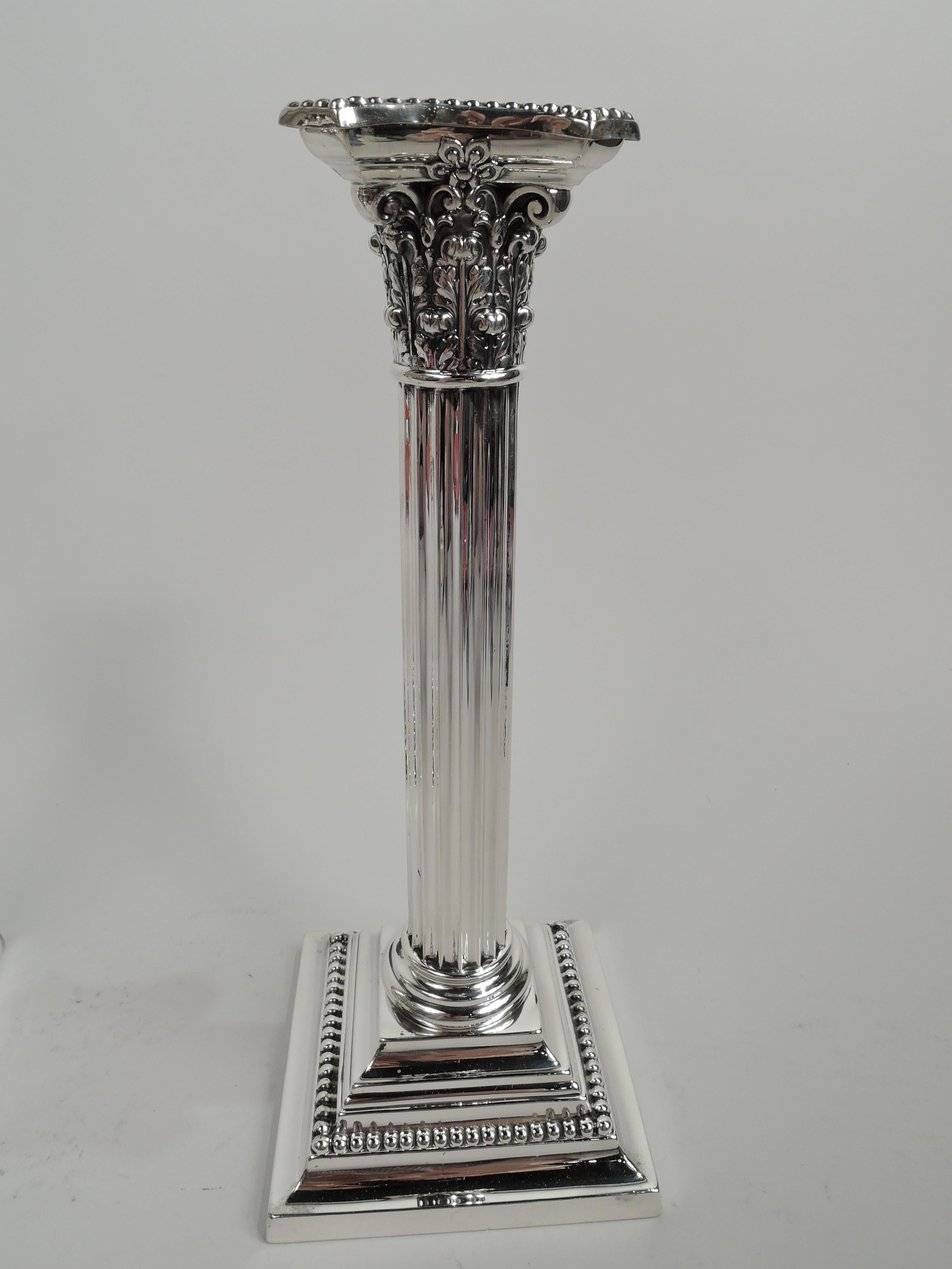 Pair of classical sterling silver candlesticks. Made by Gorham in Providence in 1909. Each: Fluted column and composite Corinthian capital. Bobeche detachable with chamfered rim. Stepped and square base. Beading. Fully marked including no. A3207 and