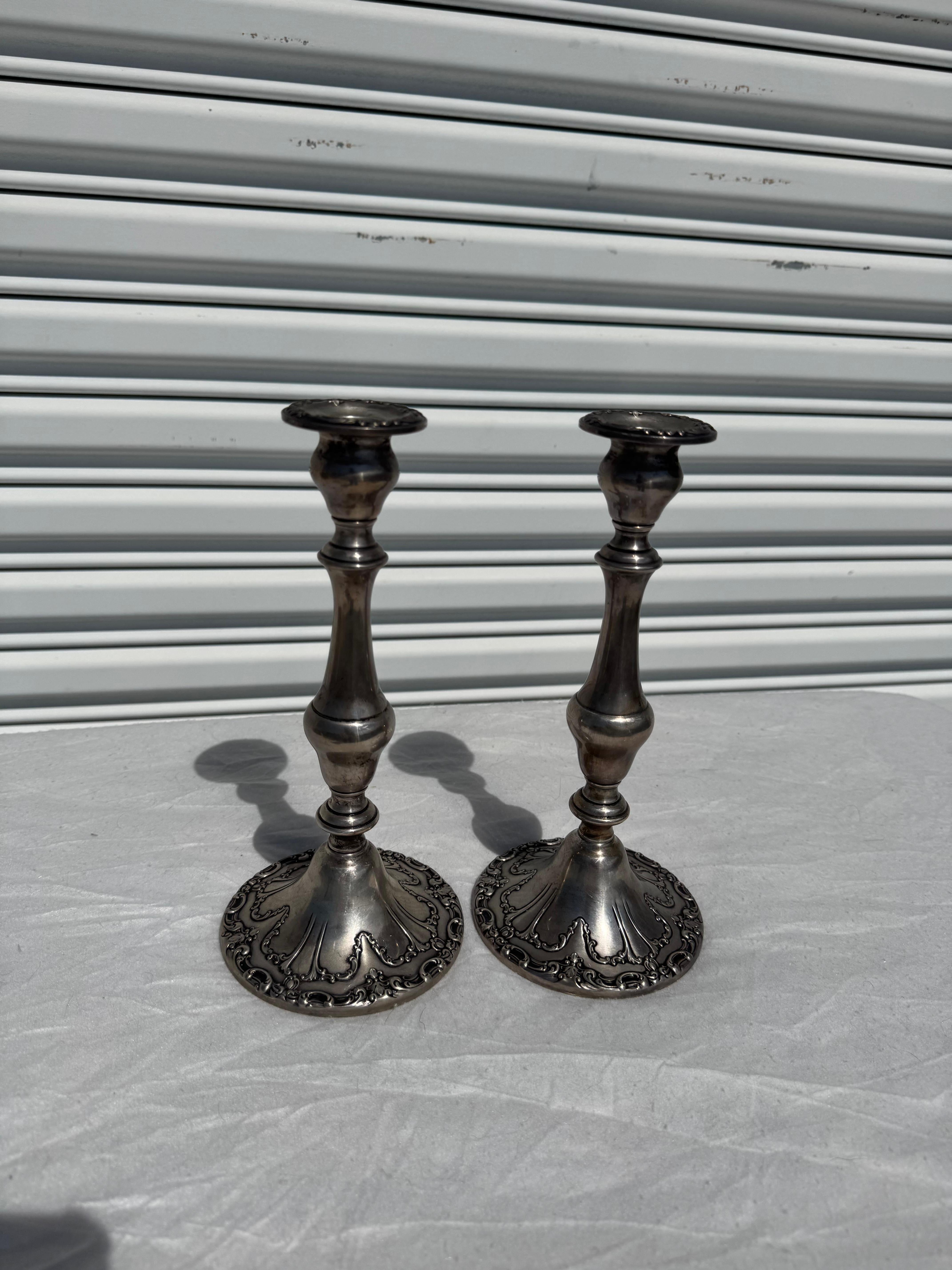 These candleholders are made by The Gorham Silver Co.
They are weighted with cement and are well designed.
They are stamped on the underside.