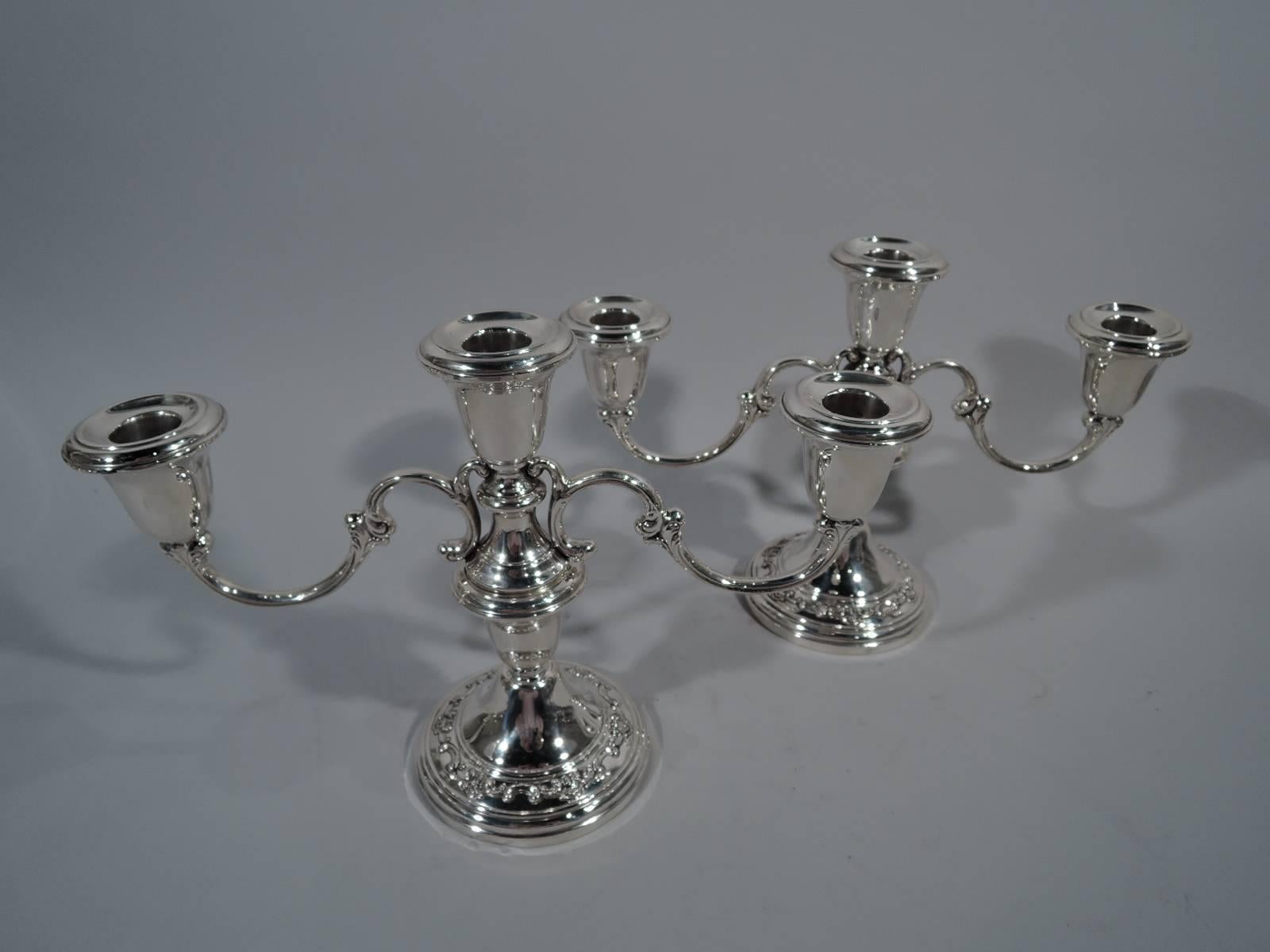 Pair of sterling silver low three-light candelabra in Strasbourg pattern. Made by Gorham in Providence. Each: Central socket with two double-scroll arms terminating in single socket. Base has applied c-scrolls and scallop shells. Converts to