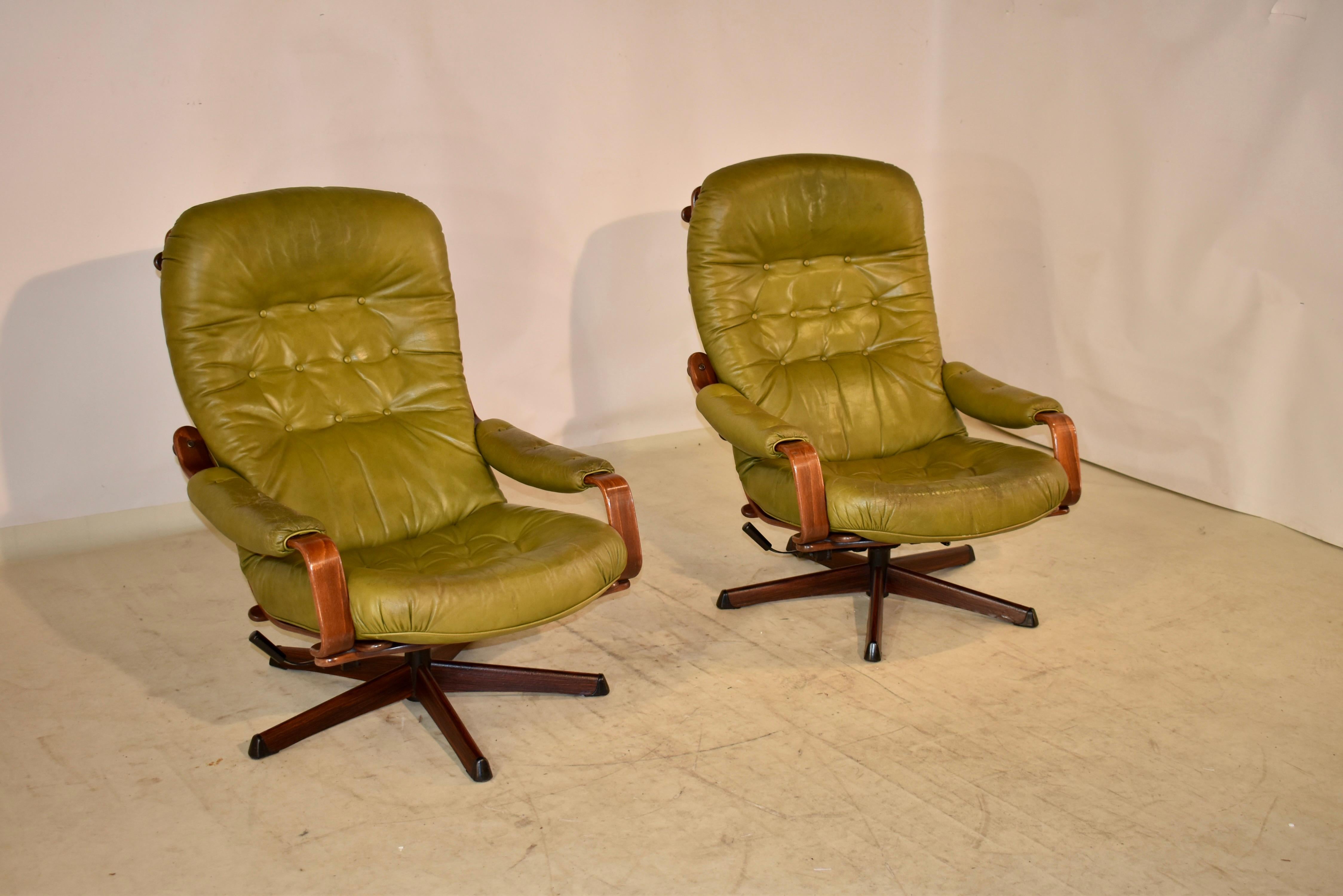 A lovely pair of Swedish midcentury lounge chairs by Gote Mobler Nassjo, with labels underneath. These lounge chairs were built for style and comfort, each with an adjustable reclining mechanism and swiveling feature. In tufted green leather with