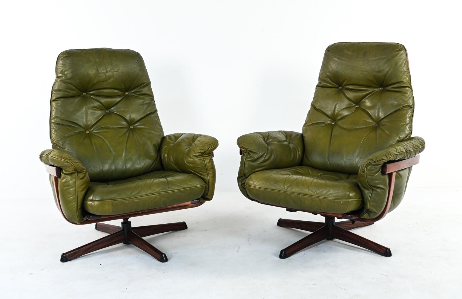 An attractive pair of Swedish mid-century easy chairs by Gote Mobler Nassjo, with label underneath. These lounge chairs were built for style and comfort, each with an adjustable reclining mechanism and swiveling feature. In tufted olive green