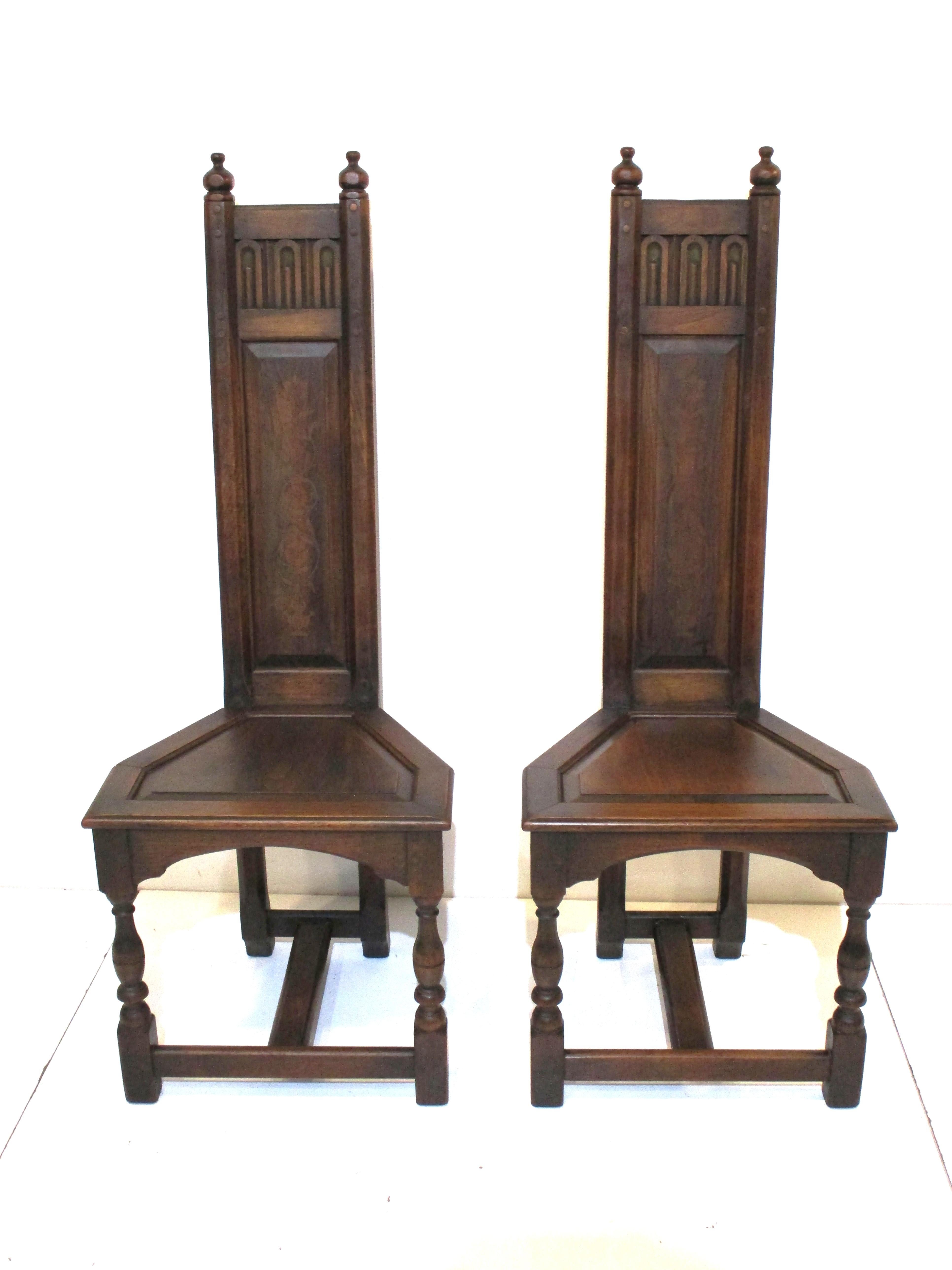 A pair of slim profile Gothic Altar chairs with turned wood legs and crown with carved detailed upper head area. The backs have a faint foliage pattern which over time has worn and aged , the perfect chairs for an area that needs some dramatic