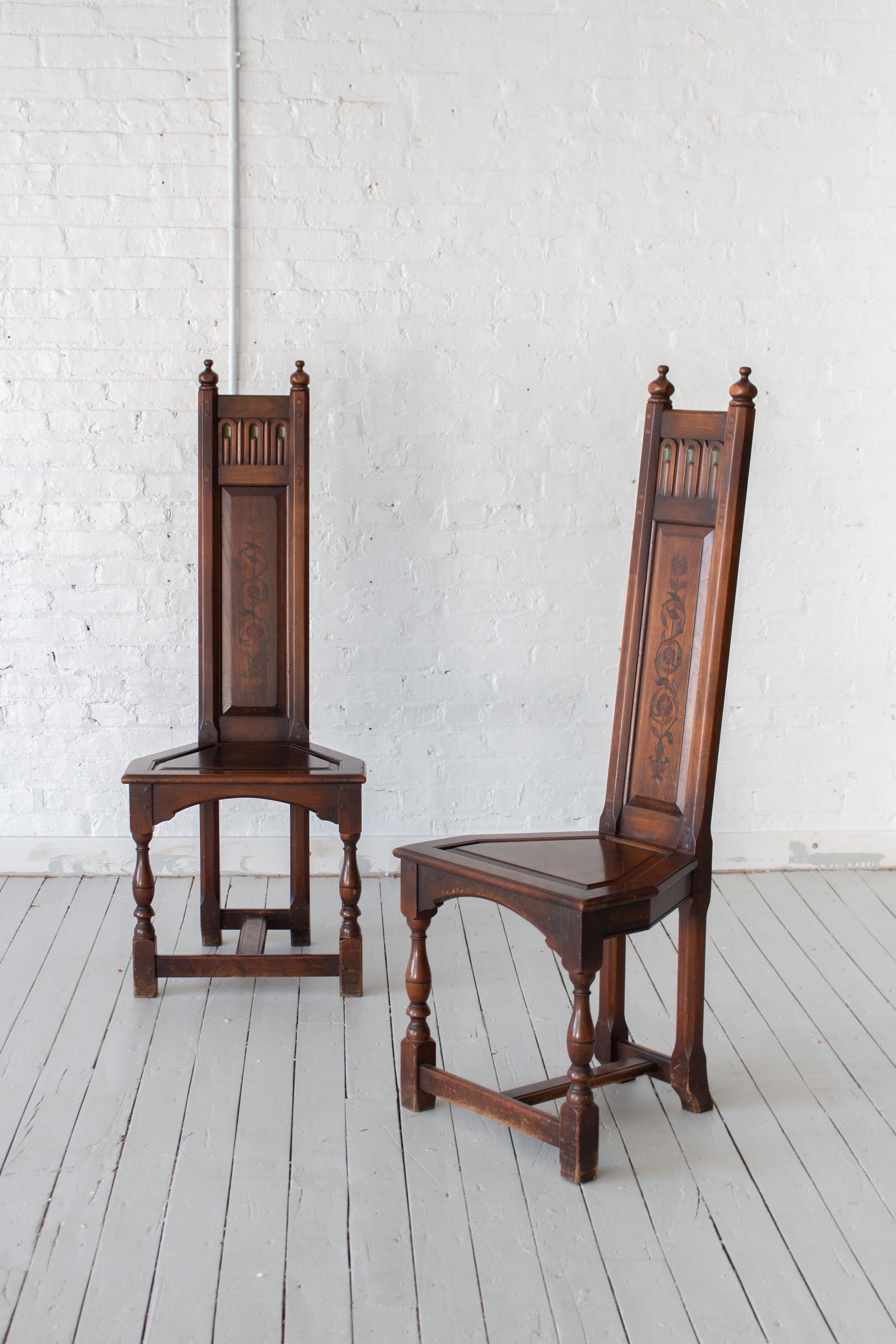 A pair of gothic revival altar chairs by Kittinger Furniture. Slender wood backs with polychrome detail. Trapezoidal seats and turned wood legs. Rich patina to wood throughout. Marked “Kittinger.”