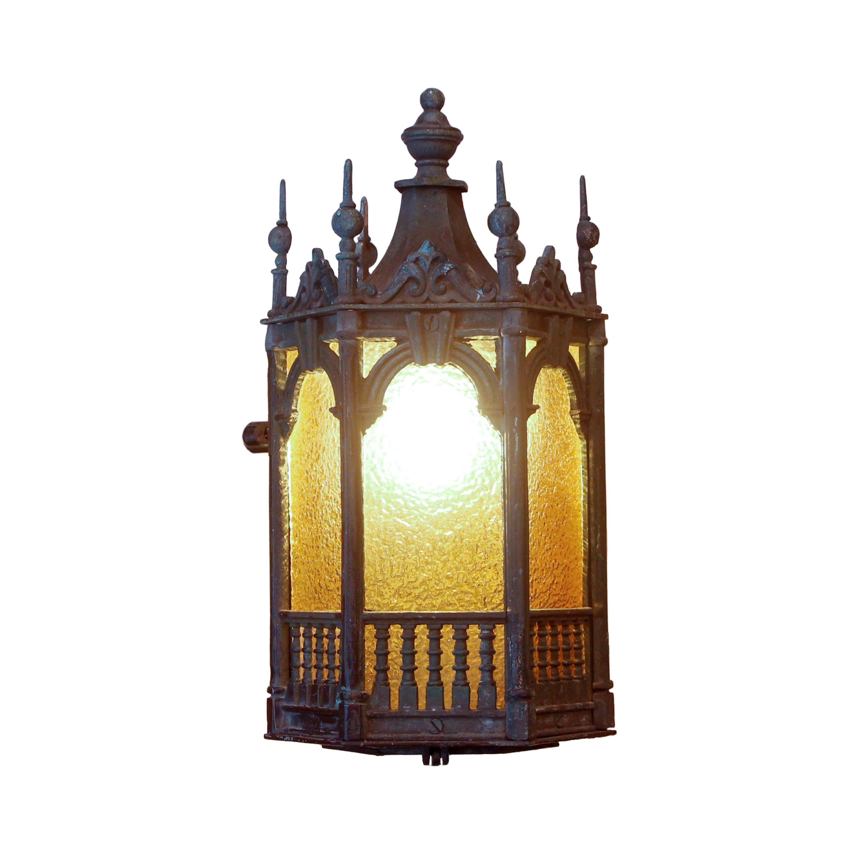 Pair of solid bronze Gothic wall sconces with a natural verdigris patina.  These lantern sconces feature textured amber glass panes. They are wired and ready to ship. Priced as a pair. Please note, this item is located in one of our NYC locations.

