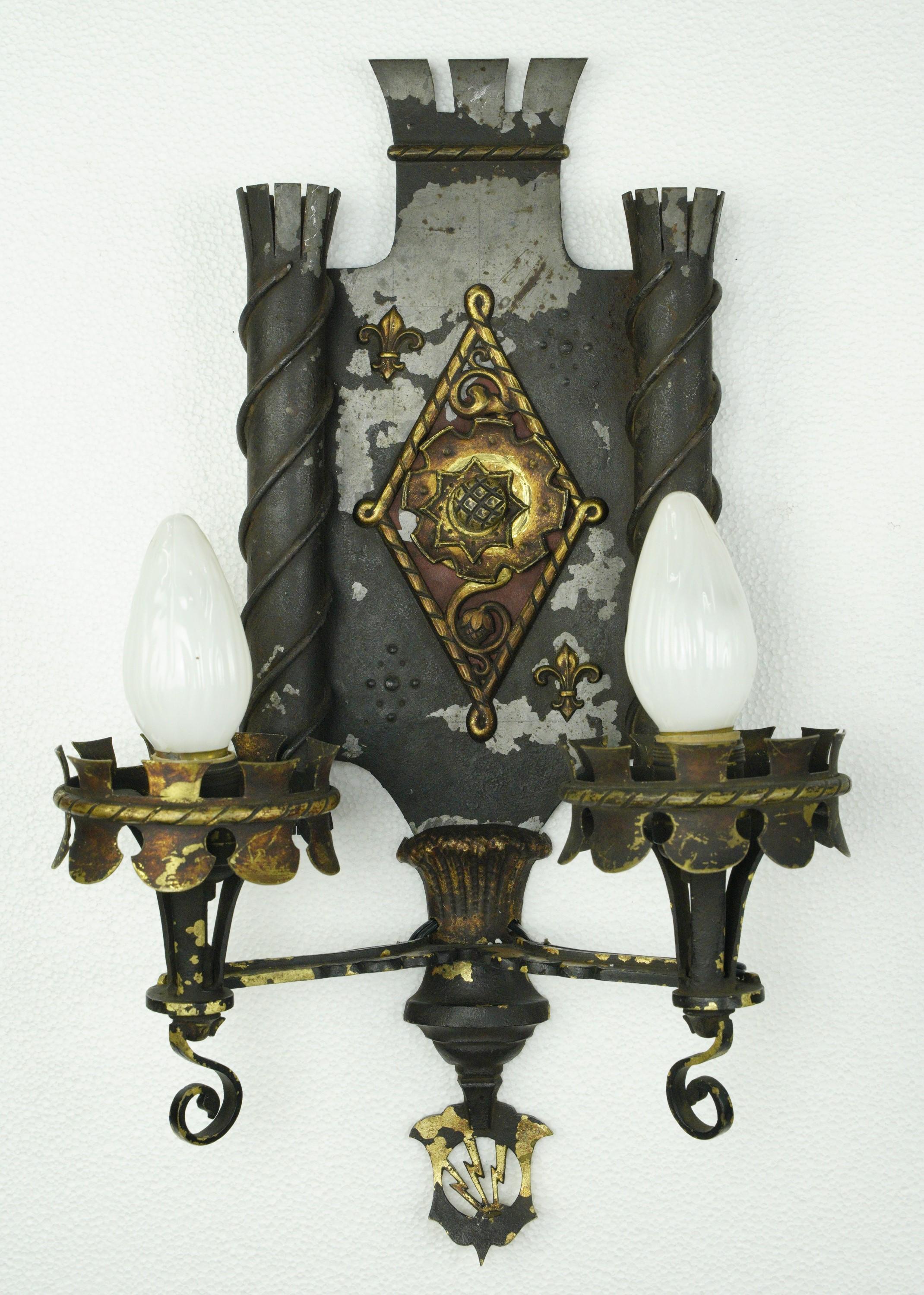 Antique Gothic wall sconces with two arms each in a wrought iron and bronze construction. Each sconce requires two candelabra light bulbs. Good rewired condition. Priced as a pair. Cleaned and restored. Please note, this item is located in one of