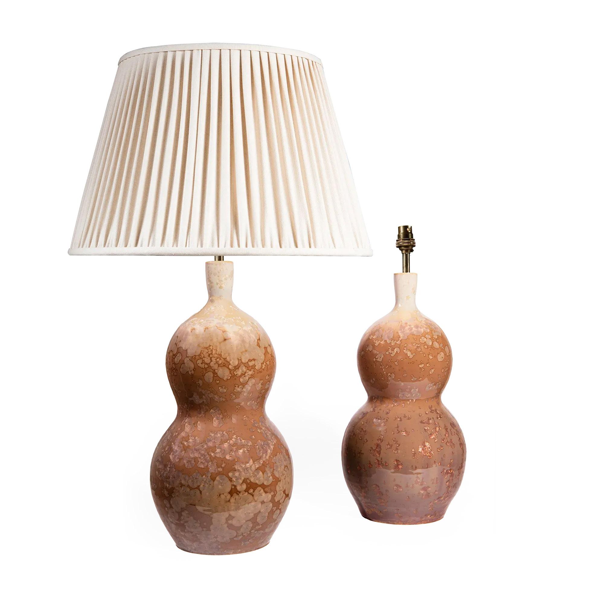 Dieses elegante Paar Keramiklampen zeichnet sich durch seine warme karamellfarbene und elfenbeinfarbene kristalline Glasur aus, die meisterhaft auf eine Doppelkürbisform aufgetragen wurde. Die Oberfläche ist voller zarter kristalliner Blüten, von